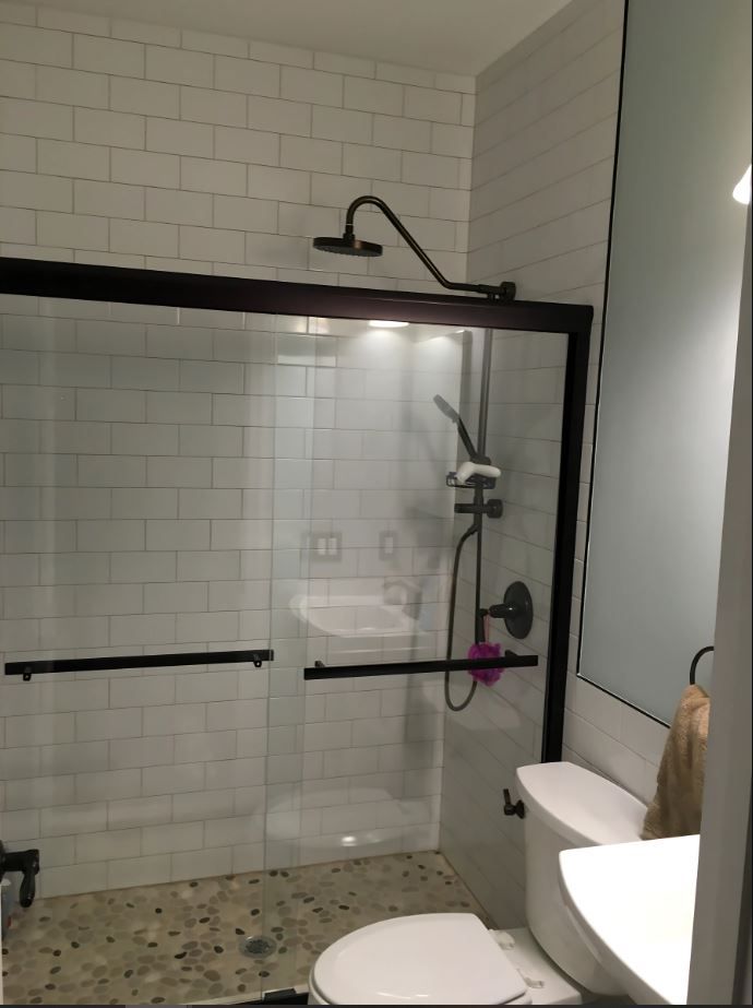 A bathroom with a toilet a sink and a shower