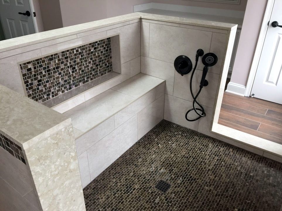 A bathroom with a dog shower and a bench.