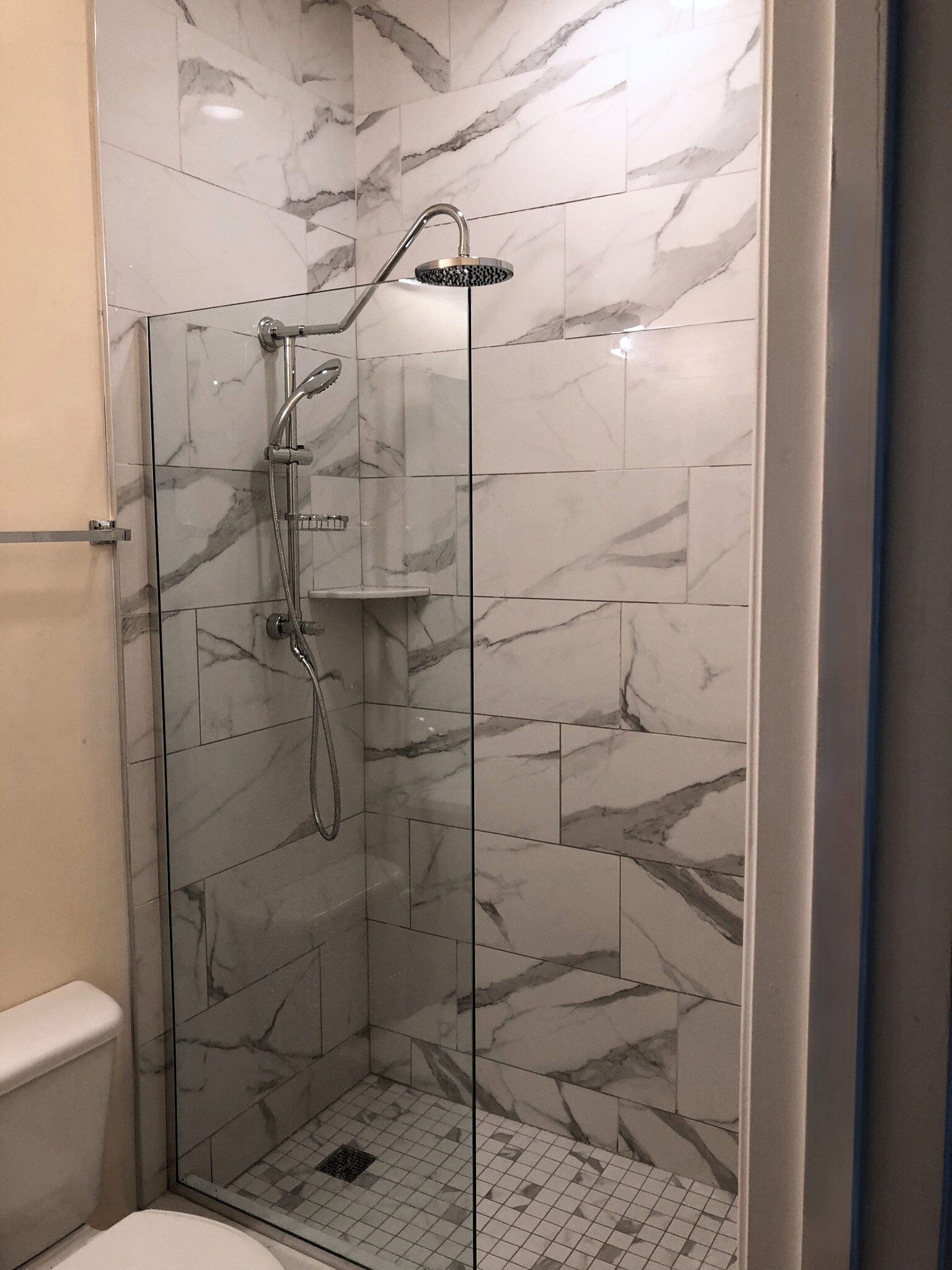 A bathroom with a walk in shower and a toilet.