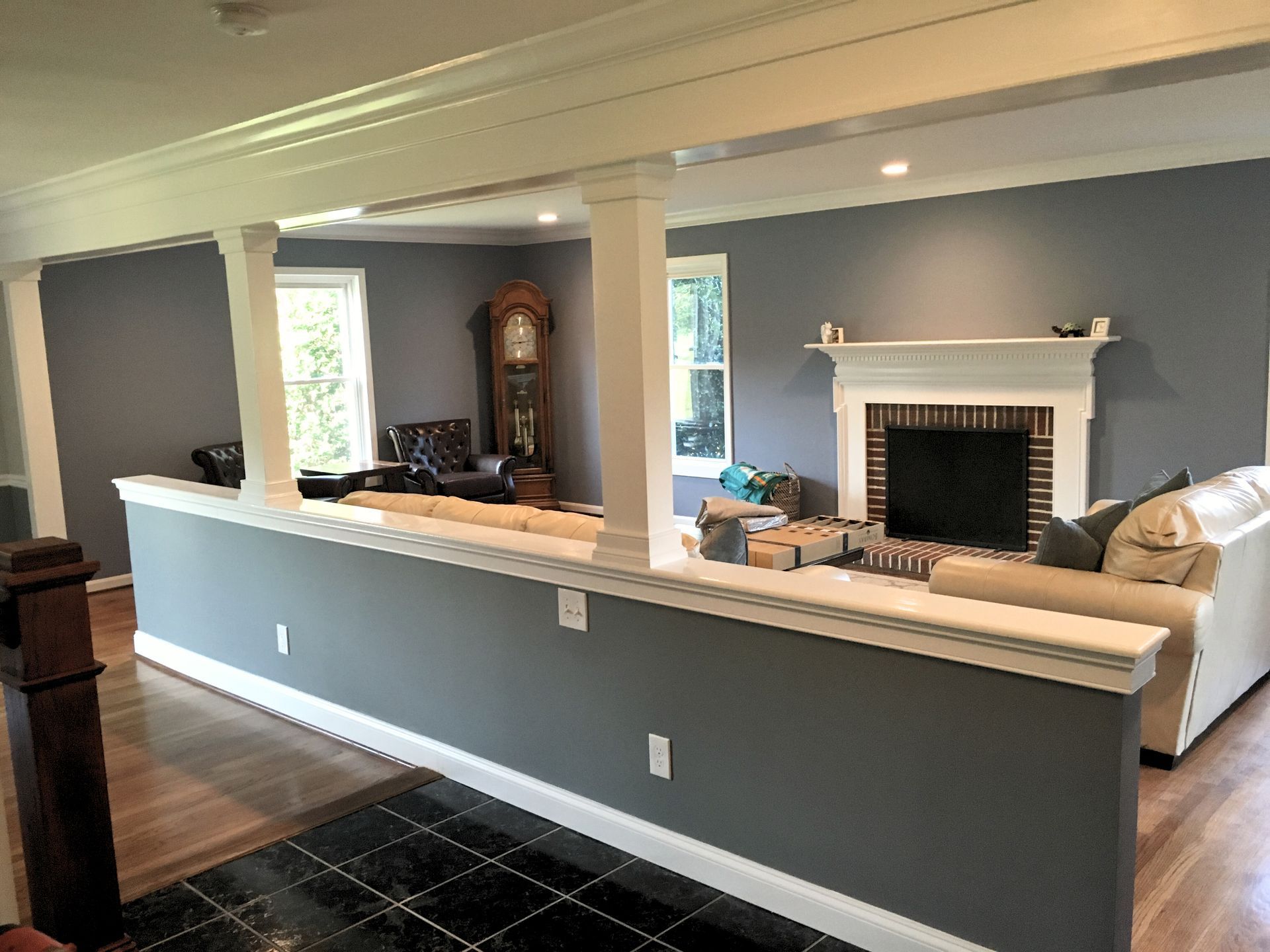 A living room with a fireplace and a clock on the wall.