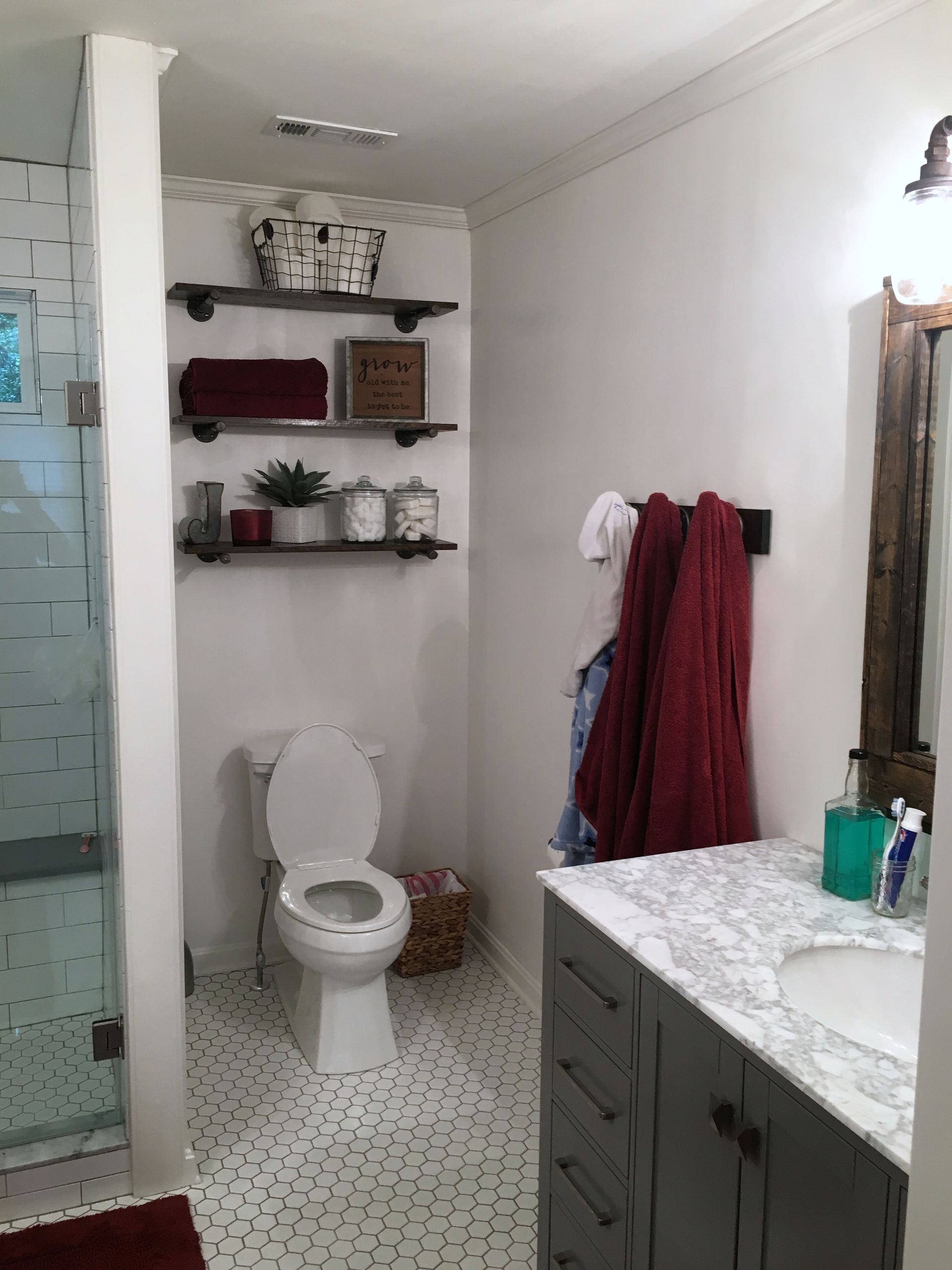 A bathroom with a toilet a sink and a mirror