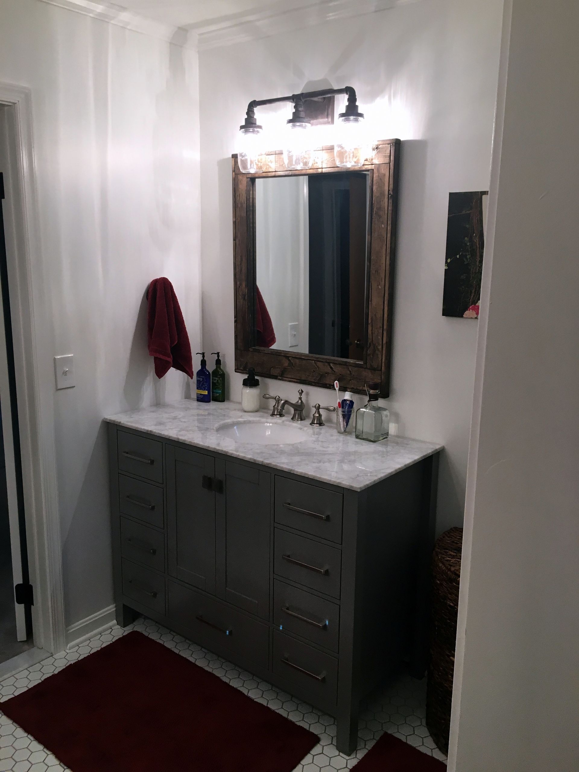 A bathroom with two sinks , a mirror and a rug.