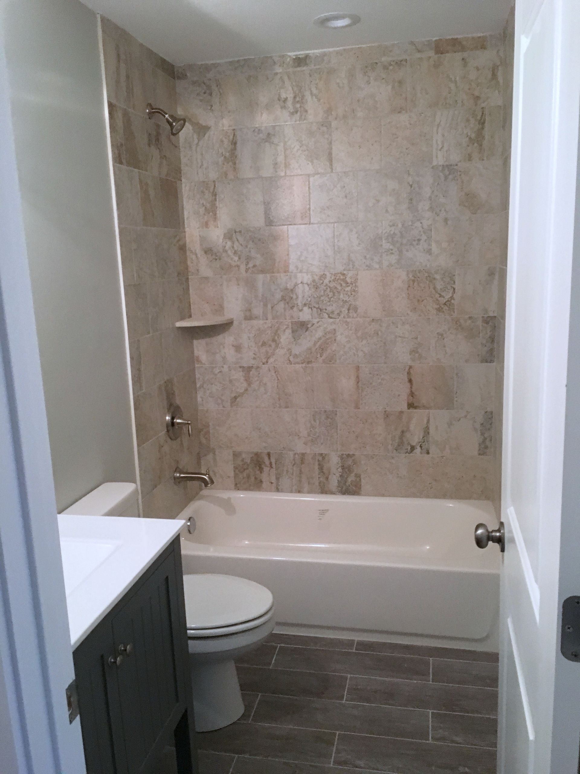 A bathroom with a tub , toilet , sink and shower.