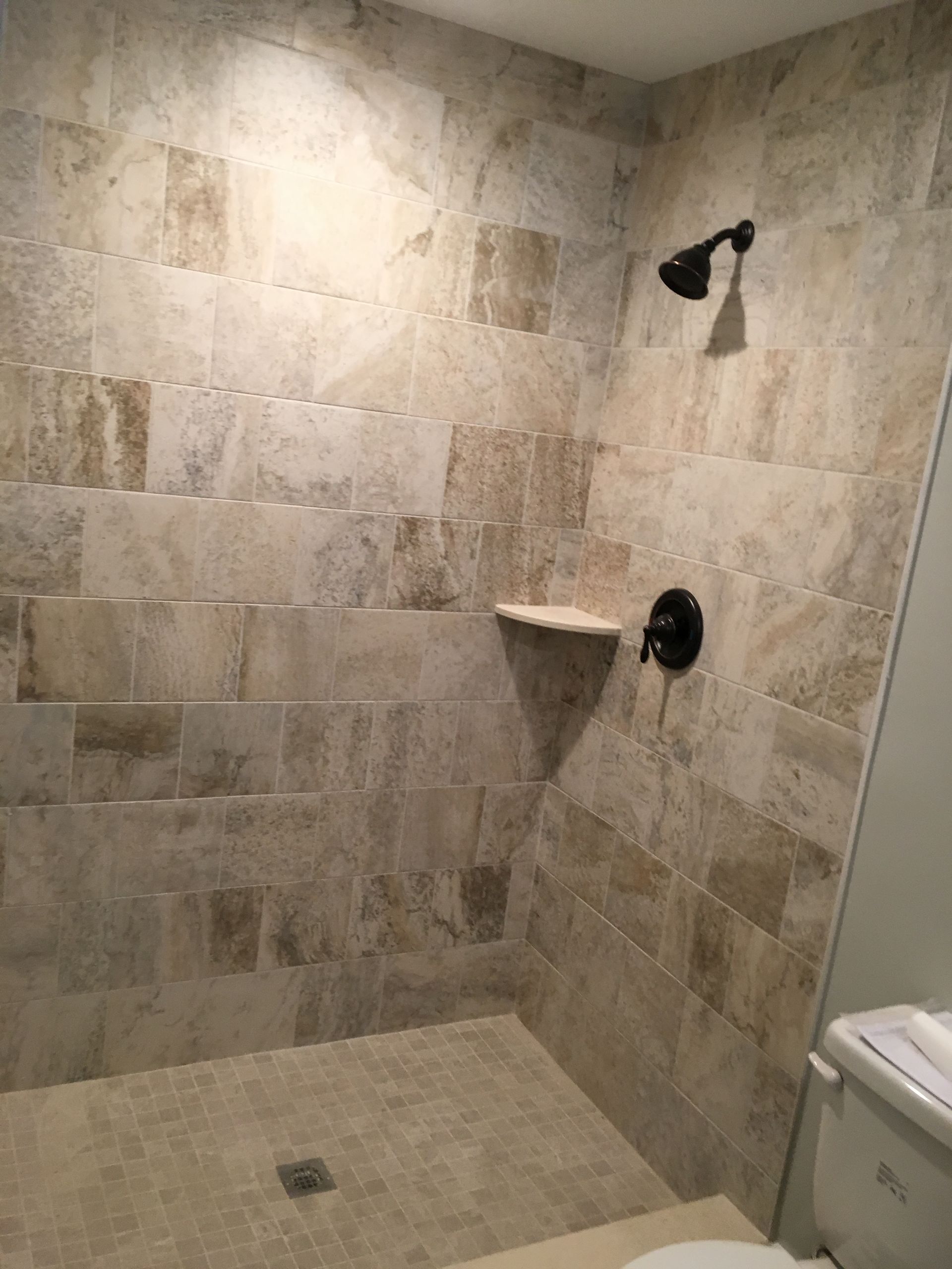 A bathroom with a walk in shower and a toilet.