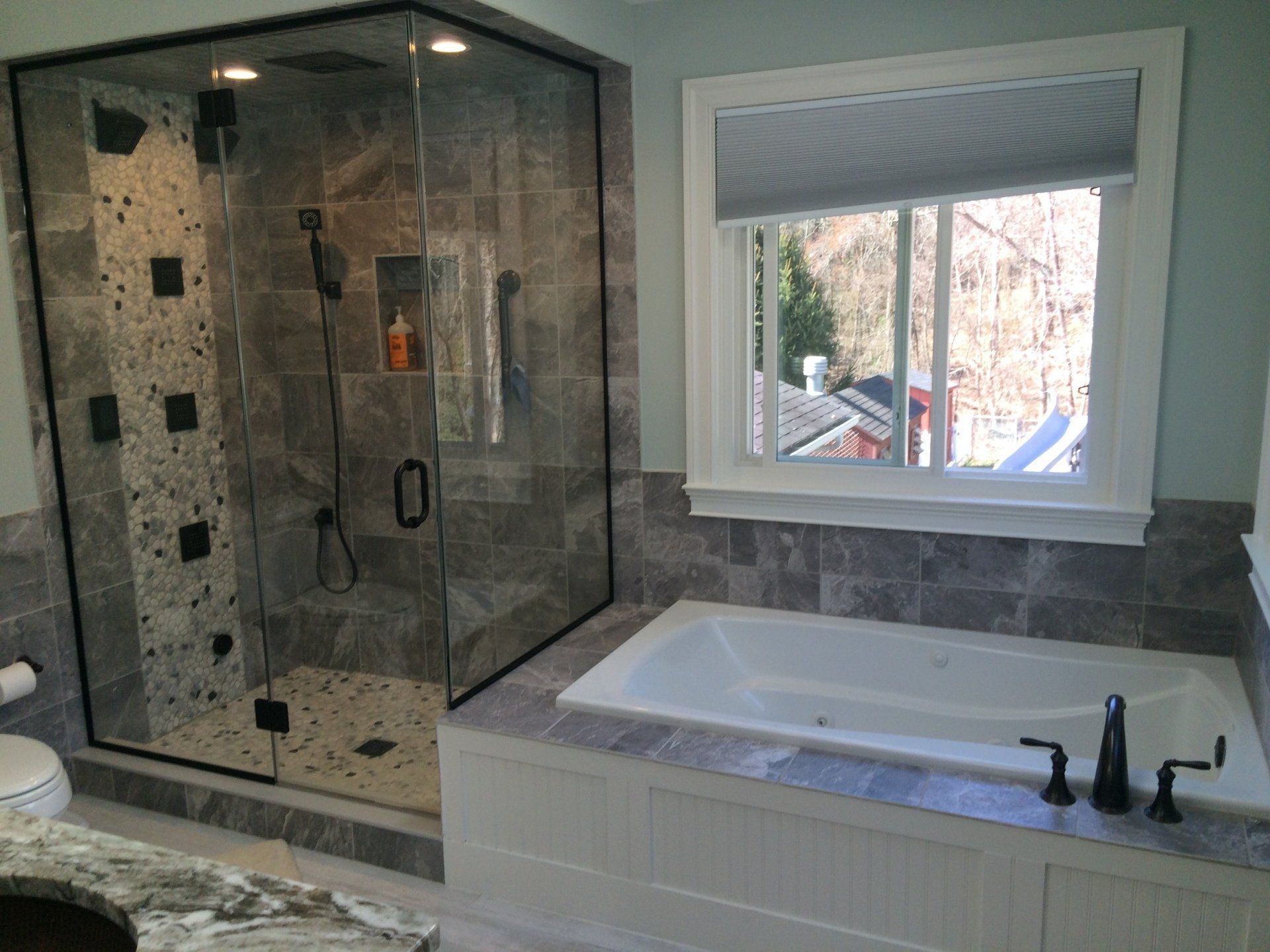 A bathroom with a tub , shower and window