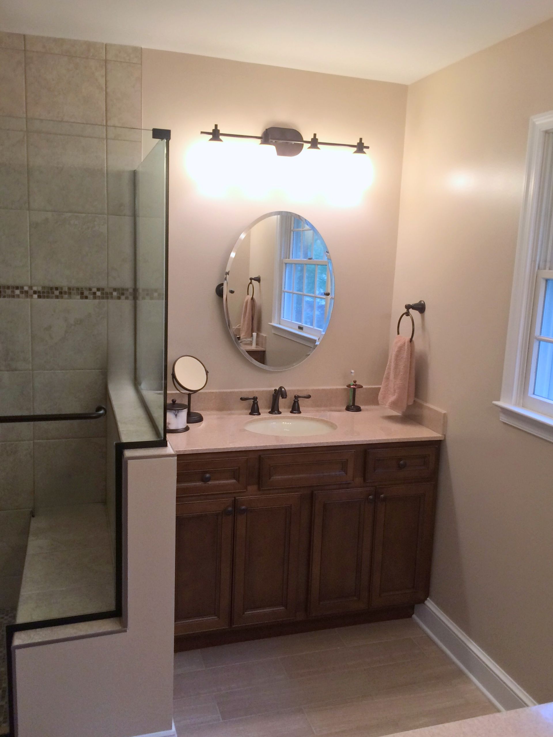 A bathroom with two sinks a mirror and a walk in shower