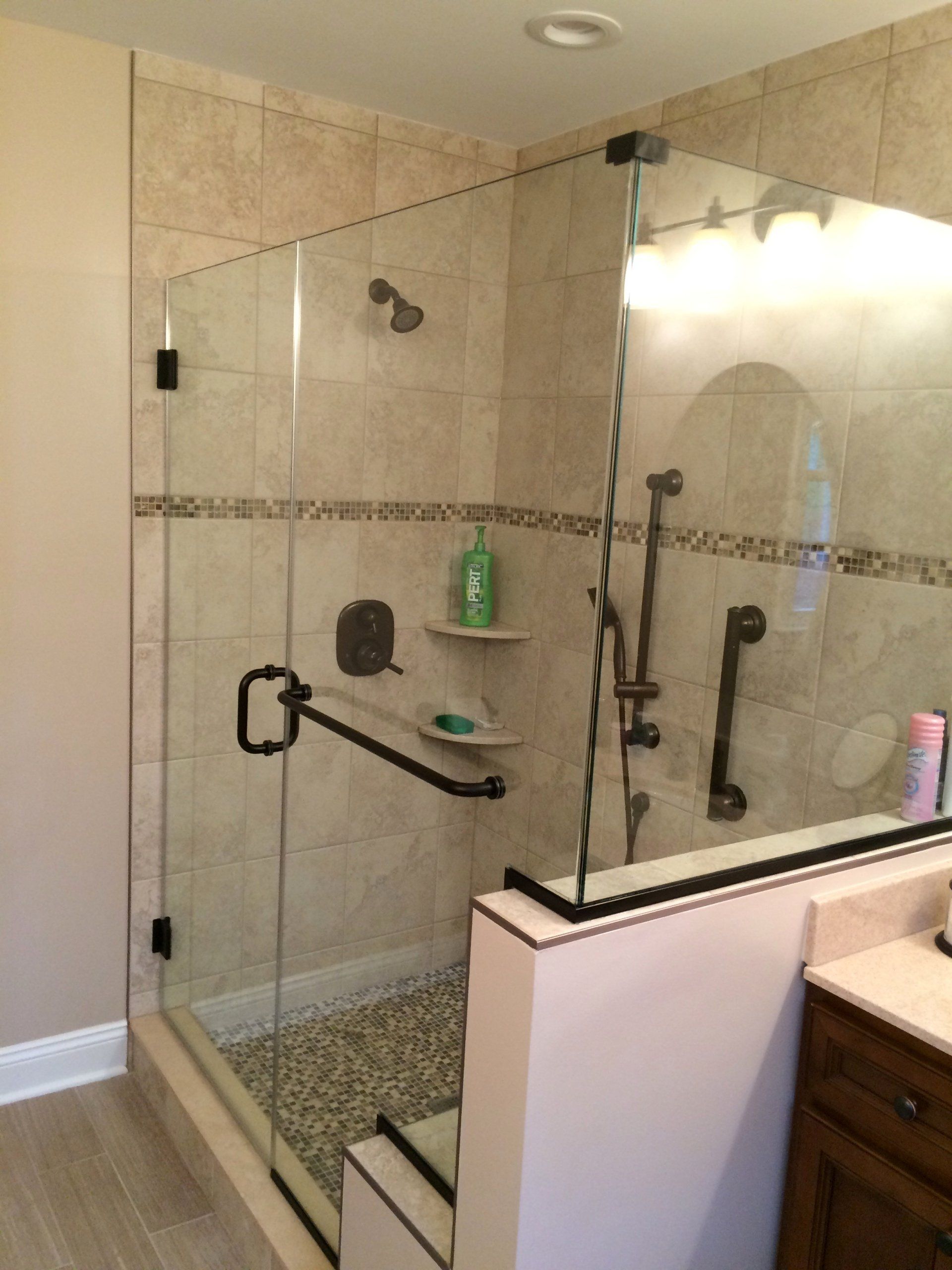 A bathroom with a walk in shower with a glass door