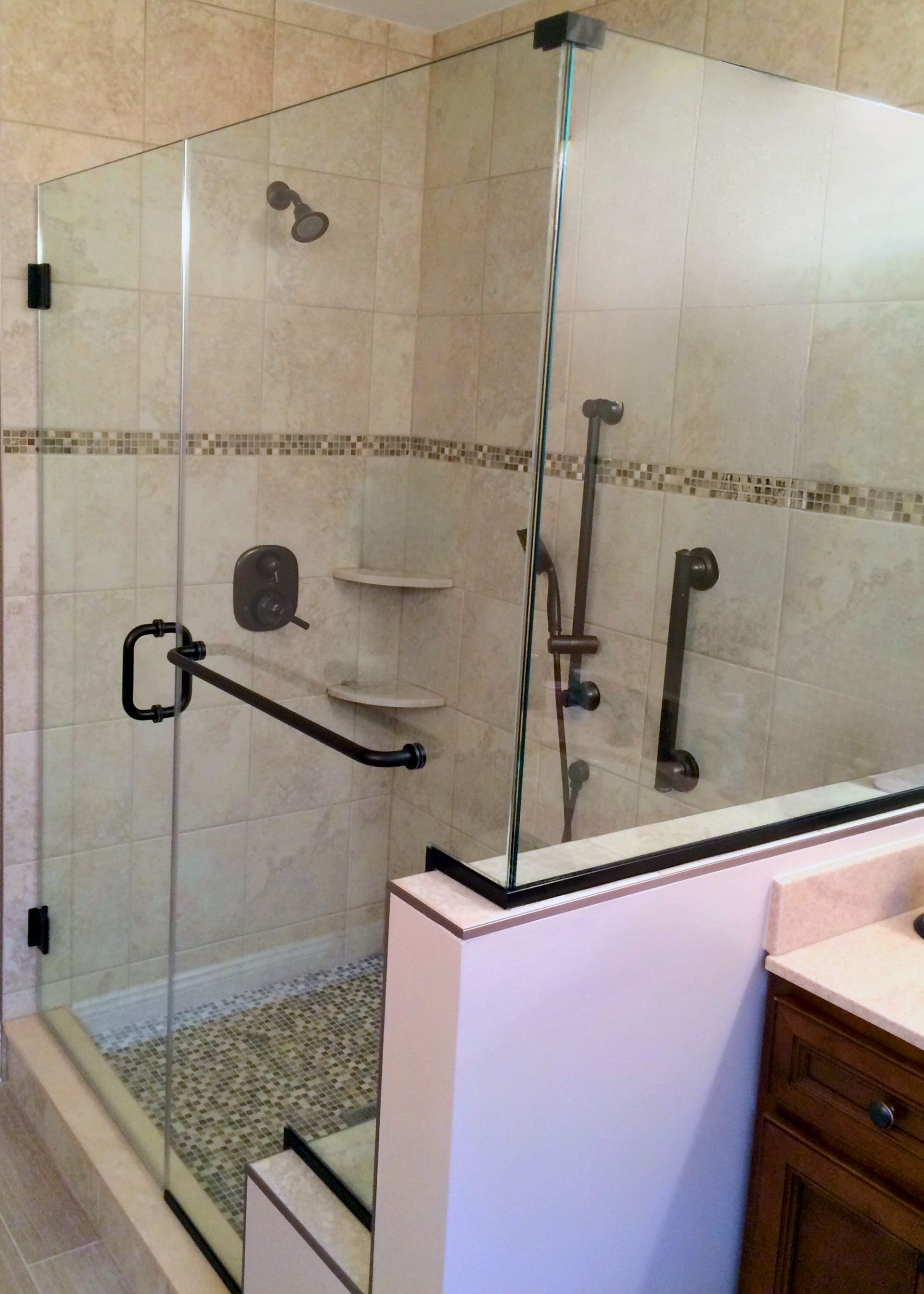 A bathroom with a walk in shower with a glass door