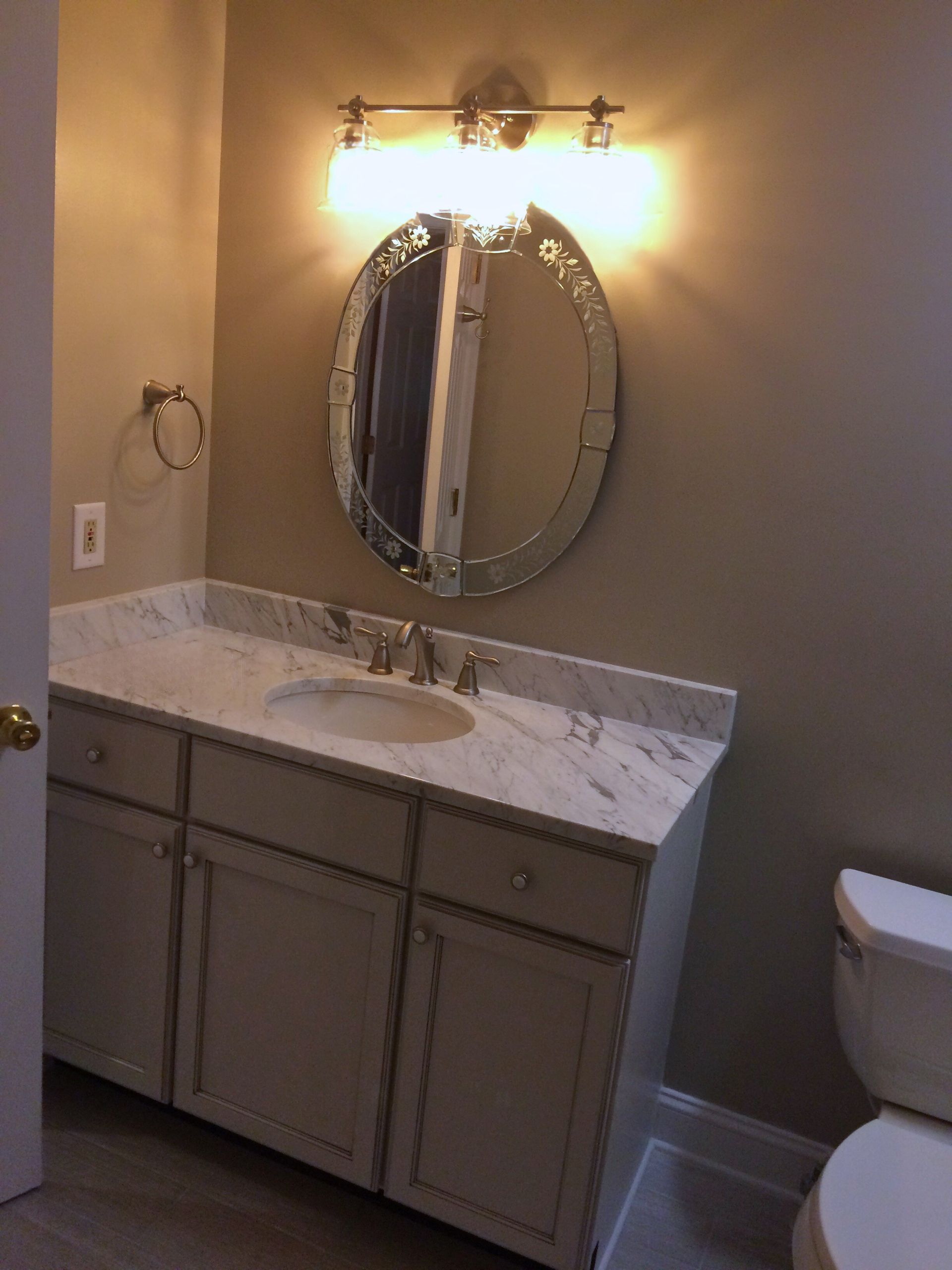 A bathroom with a sink a mirror and a toilet