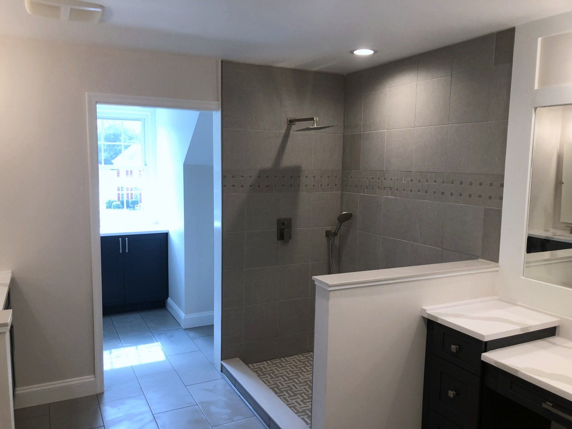 A bathroom with a walk in shower and a sink.