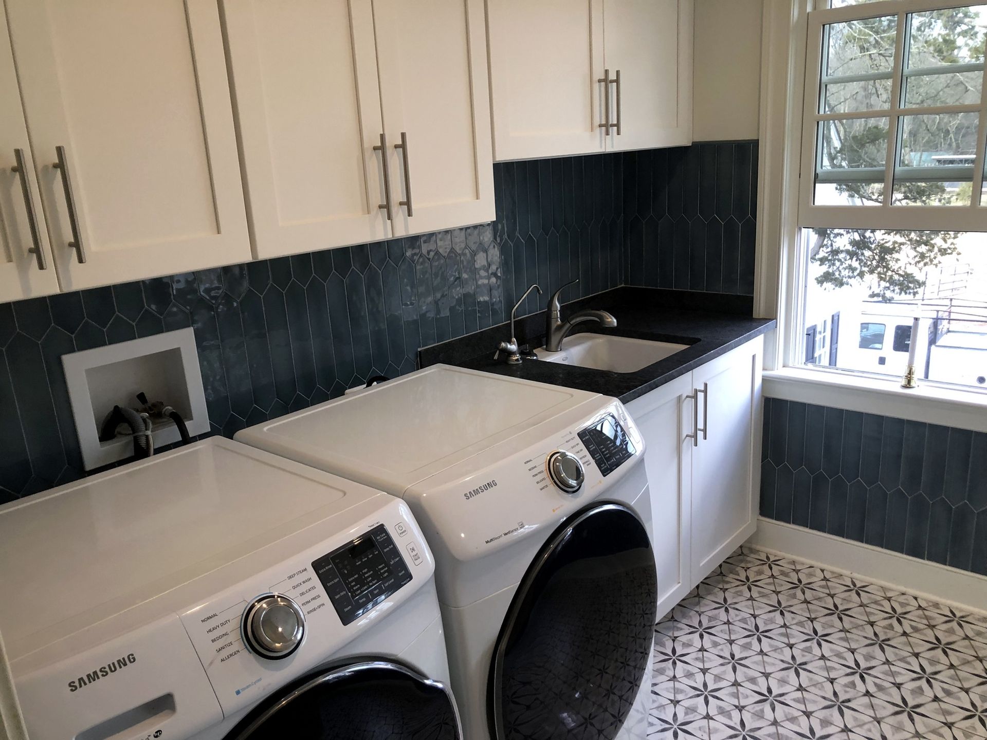 A laundry room with a washer and dryer and a sink.