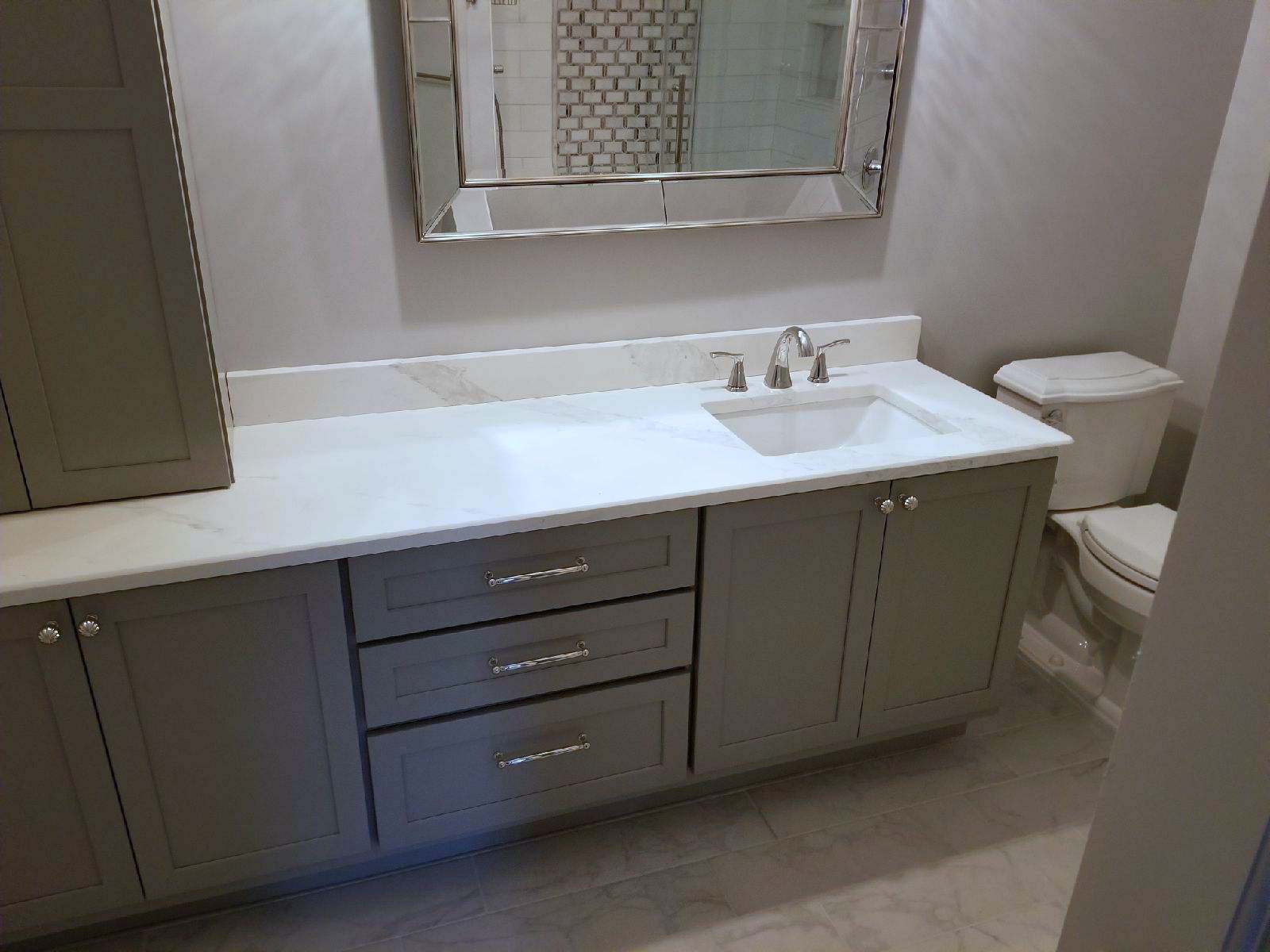 A bathroom with a sink , toilet and mirror.