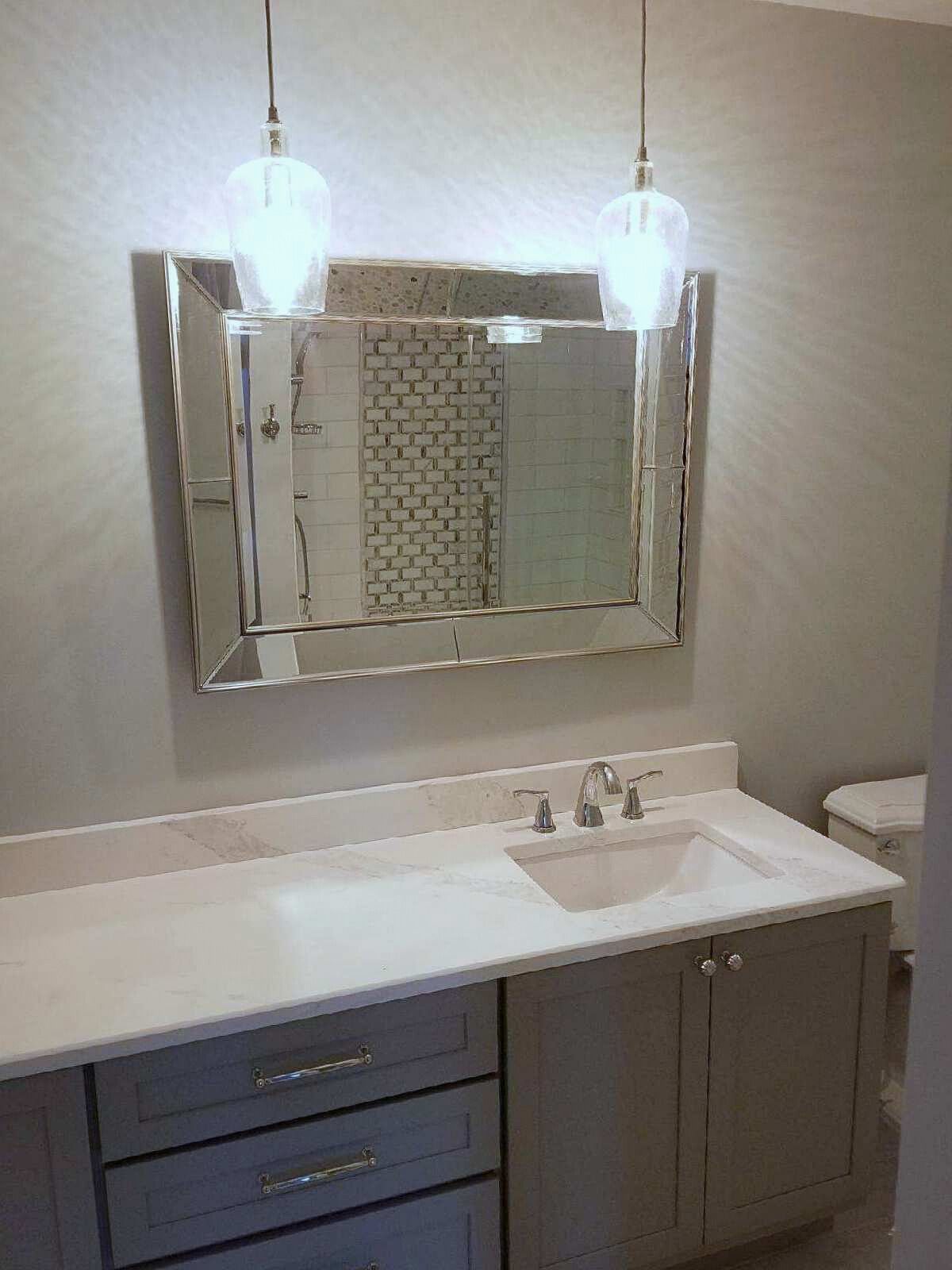 A bathroom with a sink , mirror and toilet.