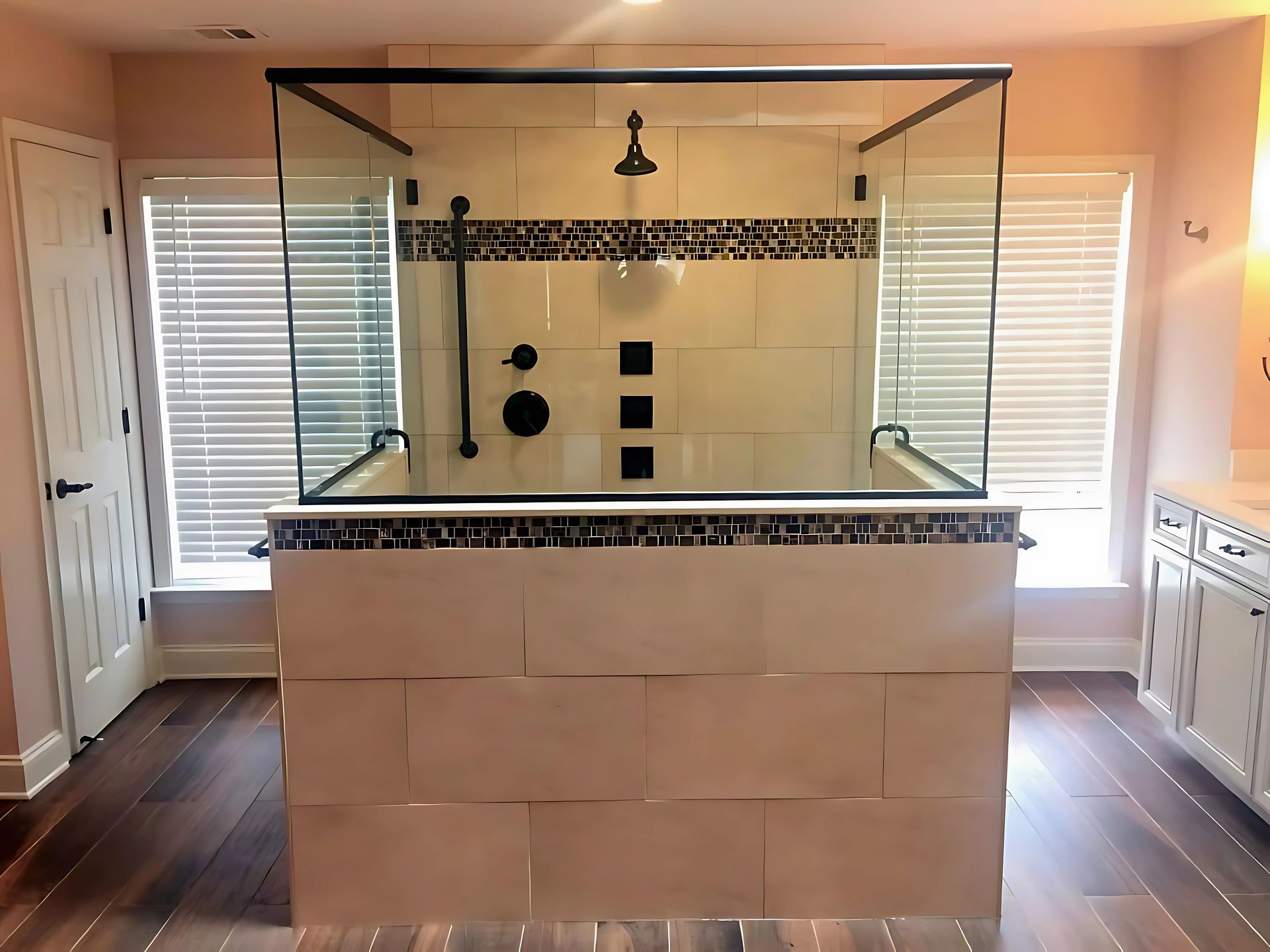 A bathroom with a walk in shower with a glass door