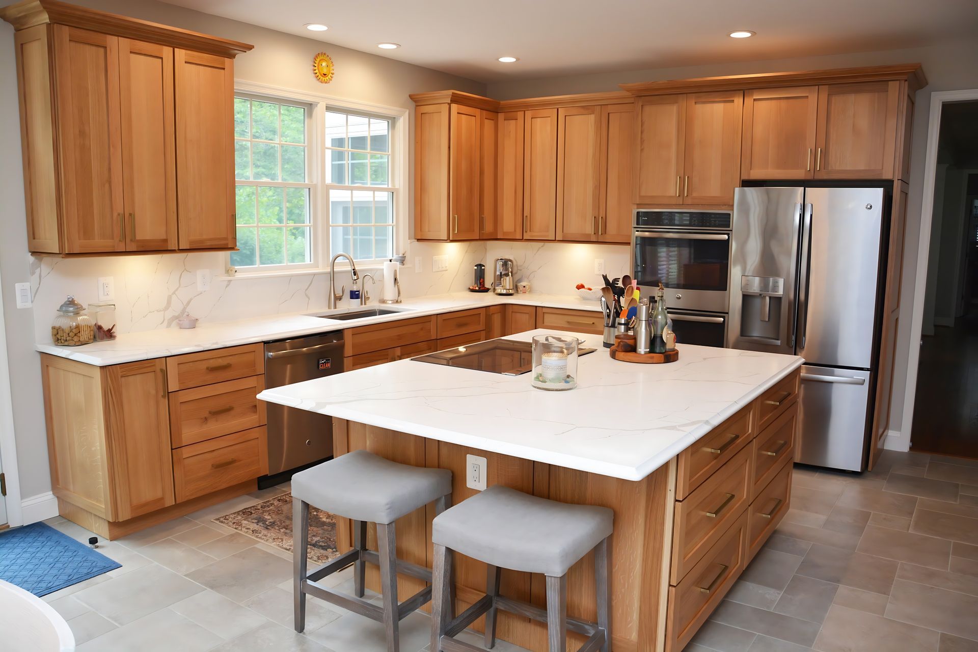 A kitchen with wooden cabinets , stainless steel appliances , and a large island.