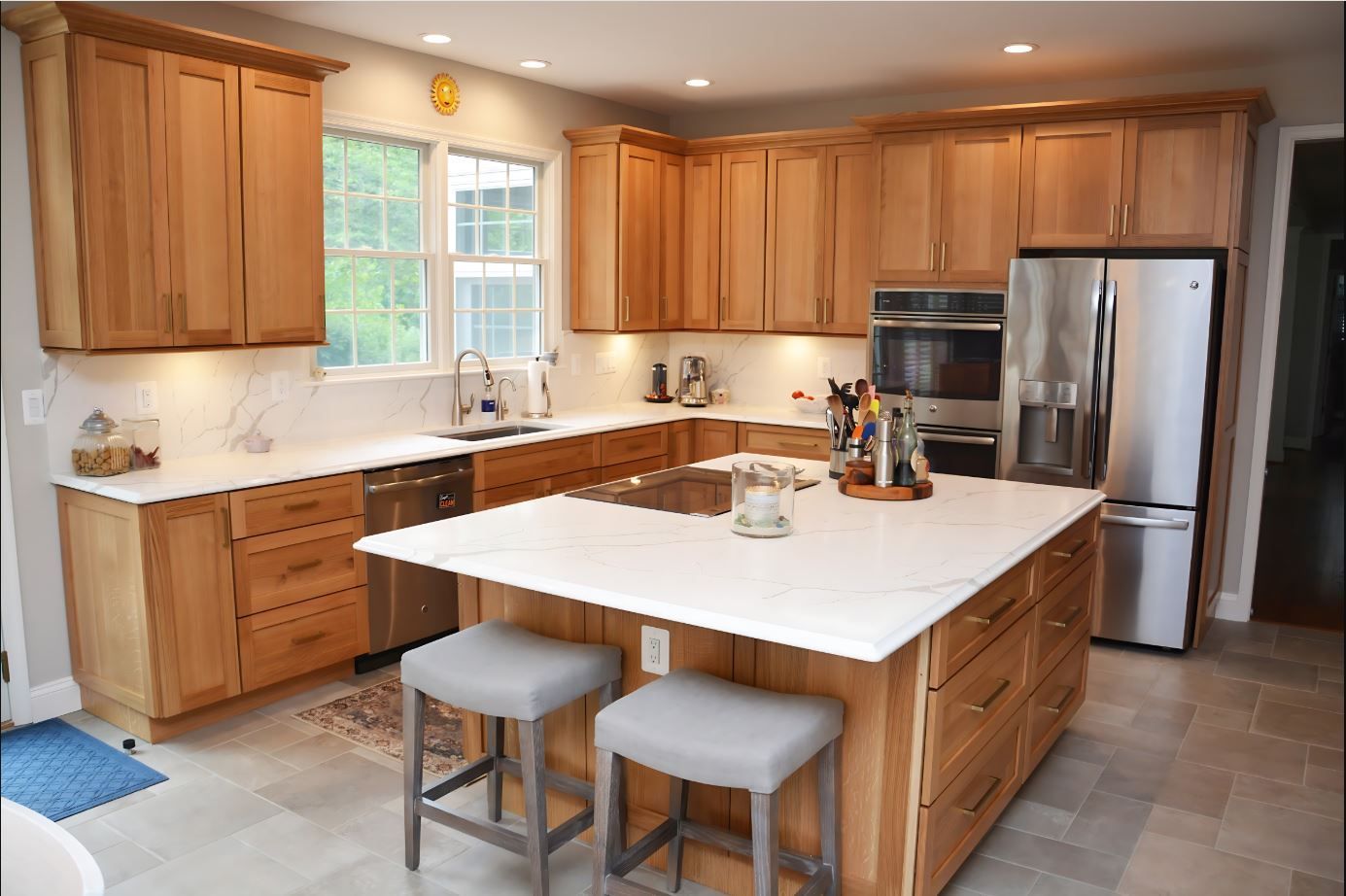 A kitchen with wooden cabinets , stainless steel appliances , and a large island.