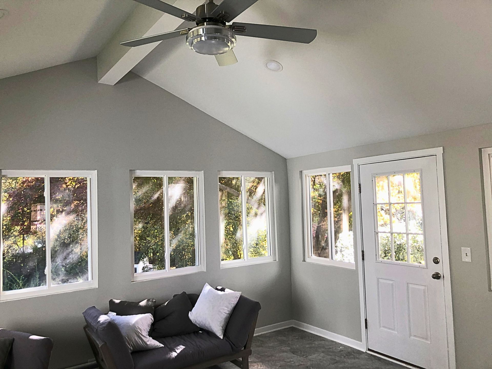 A living room with a couch and a ceiling fan.
