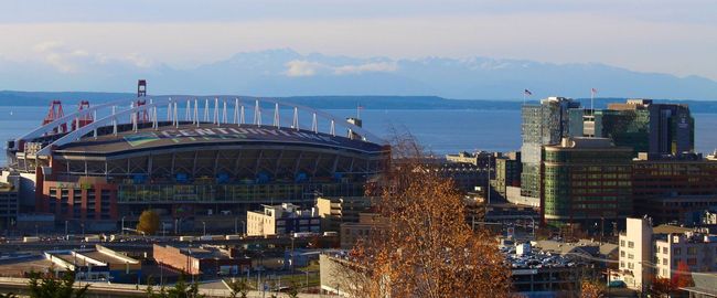 An aerial view of a city with a large stadium in the background