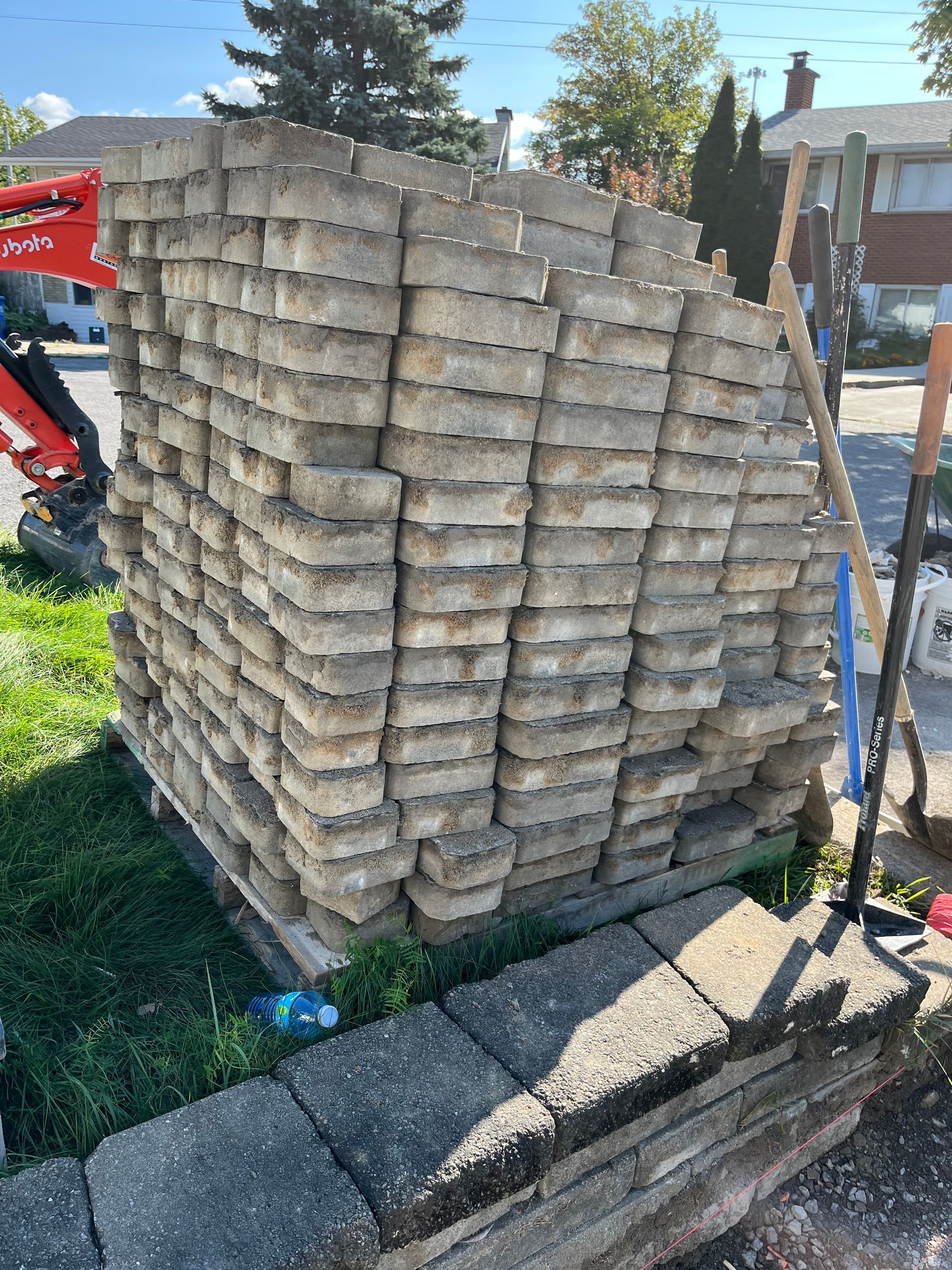 A pile of bricks stacked on top of each other on a sidewalk.
