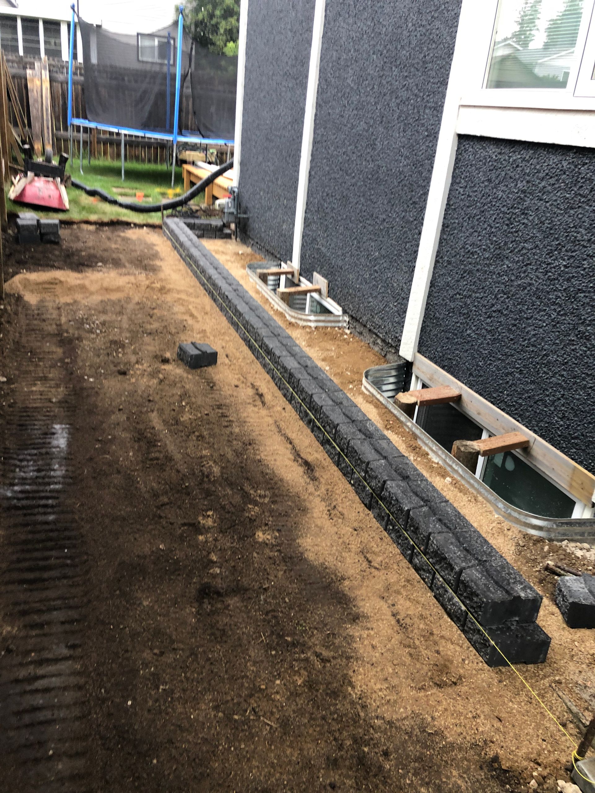 A trampoline is being built in the backyard of a house.
