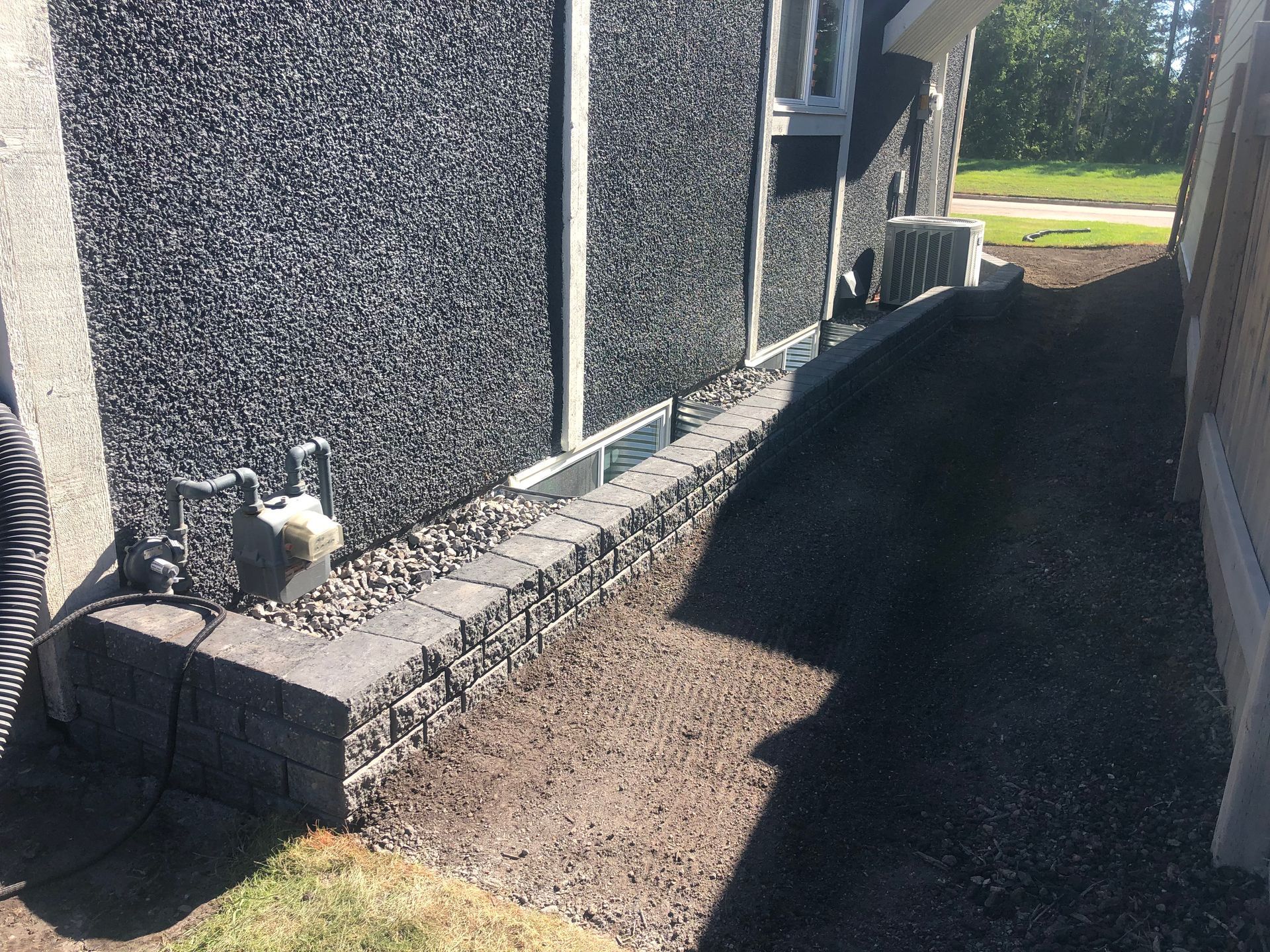 A brick wall is being built next to a house.