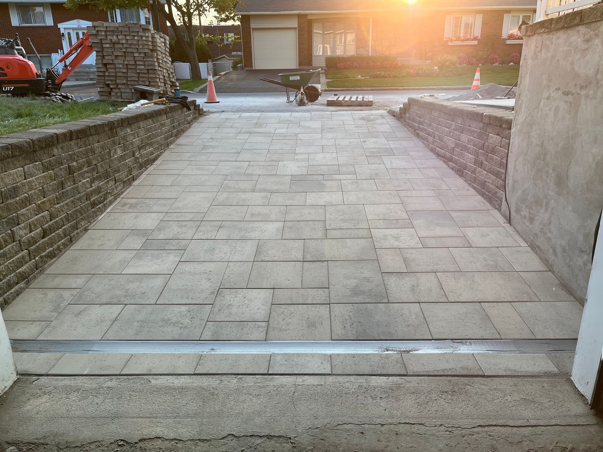 A brick walkway is being built in front of a house.