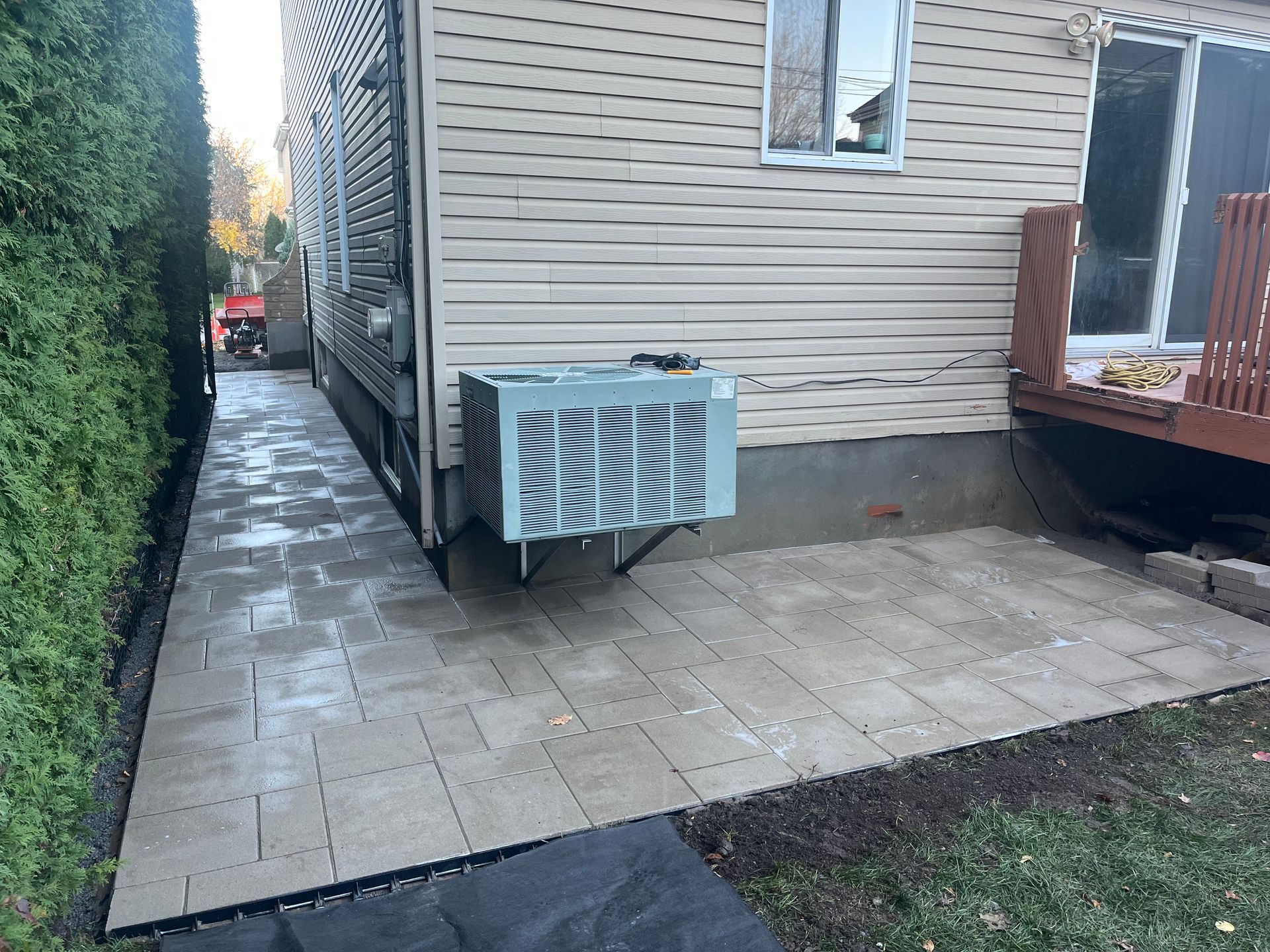 A walkway leading to a house with a patio and a deck.