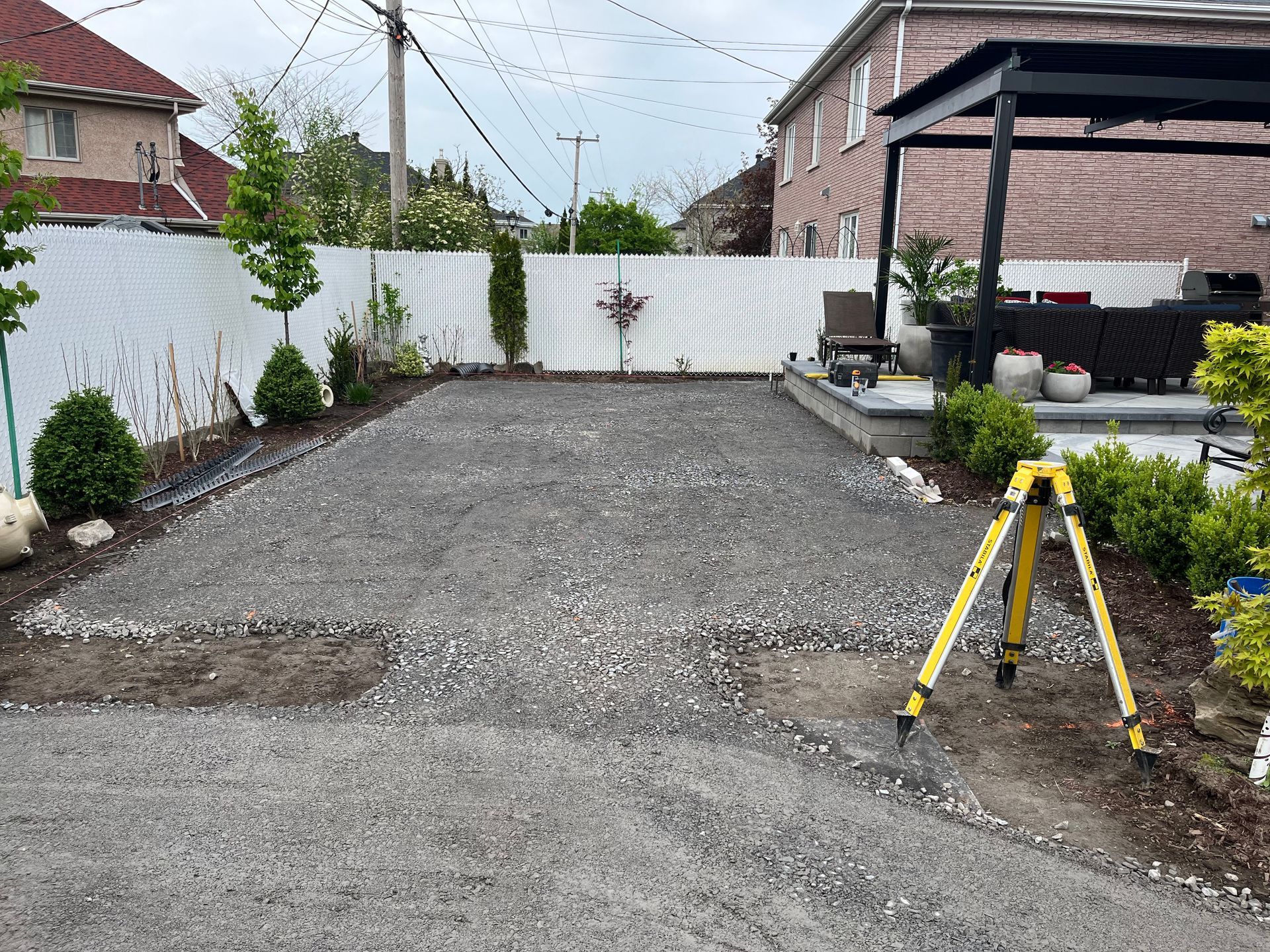 A tripod is sitting in the middle of a gravel driveway.