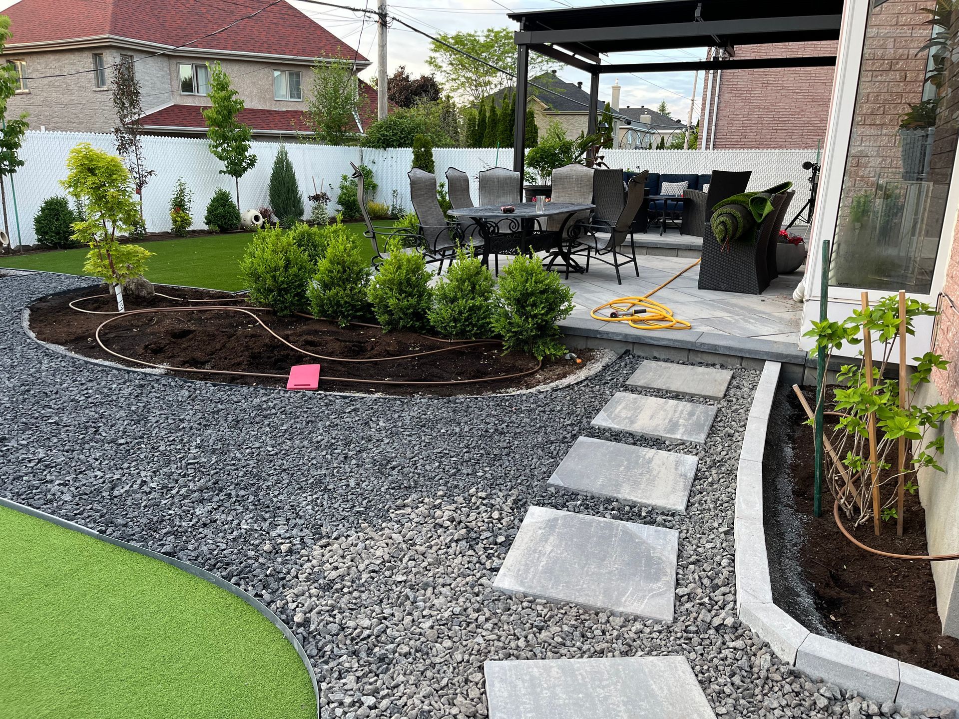 A patio with a table and chairs in the backyard of a house.