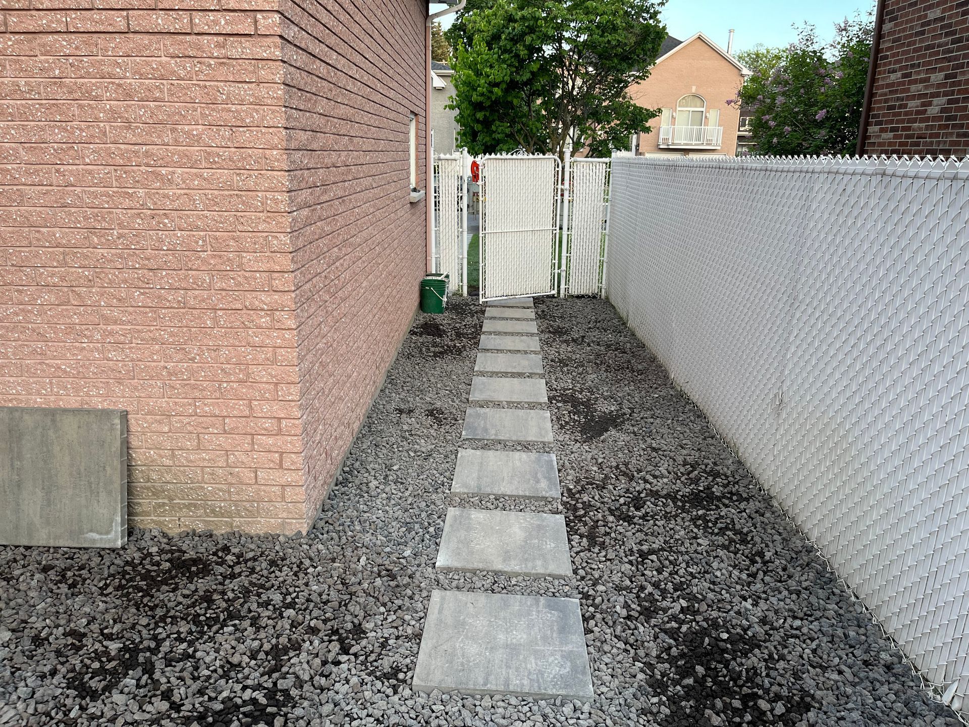 A brick building with a chain link fence and a walkway leading to it
