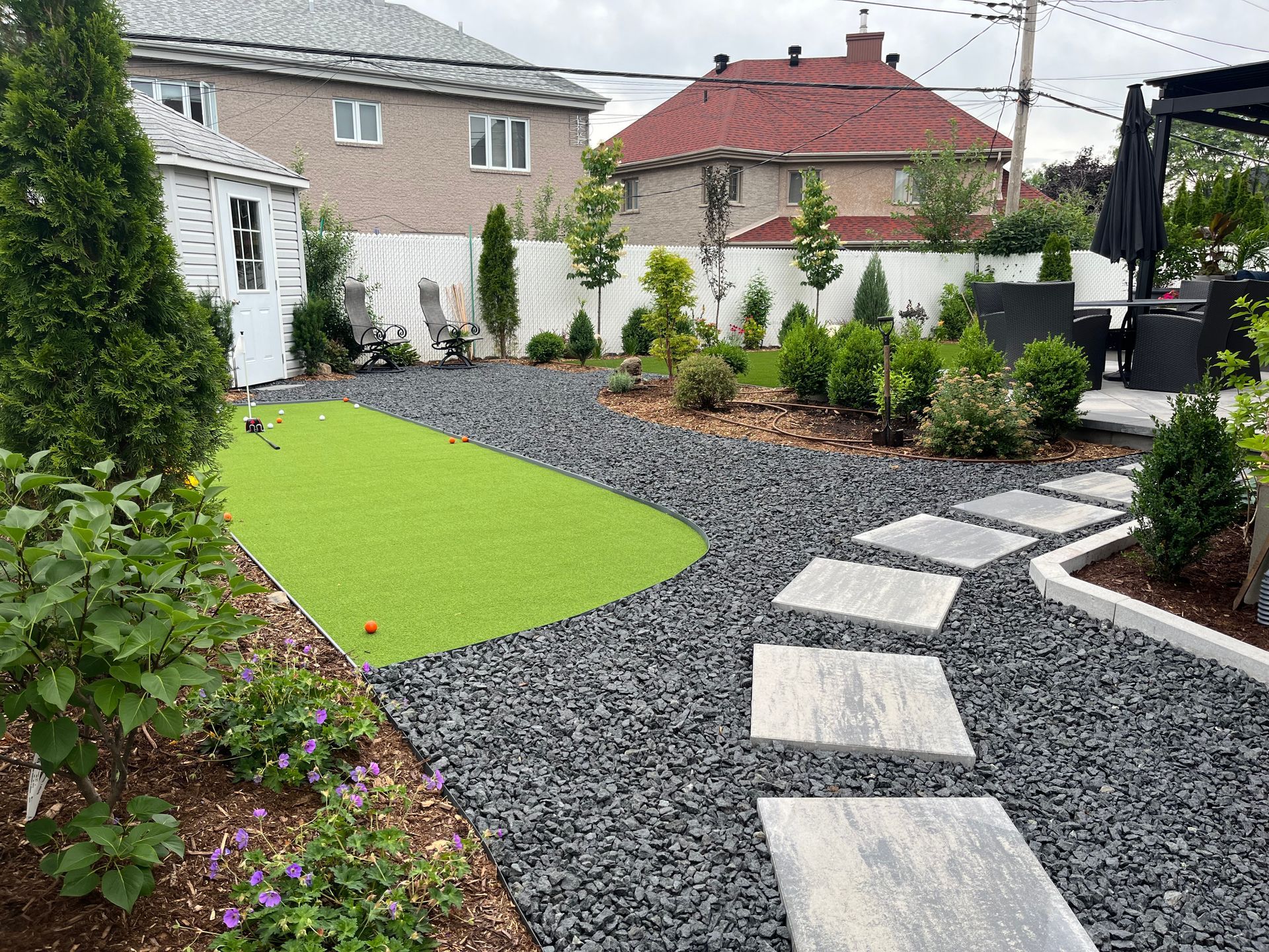 There is a putting green in the middle of the yard.