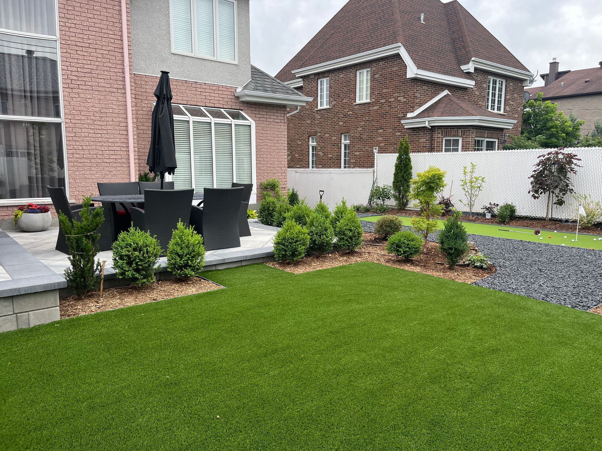 A backyard with a table and chairs in front of a house.