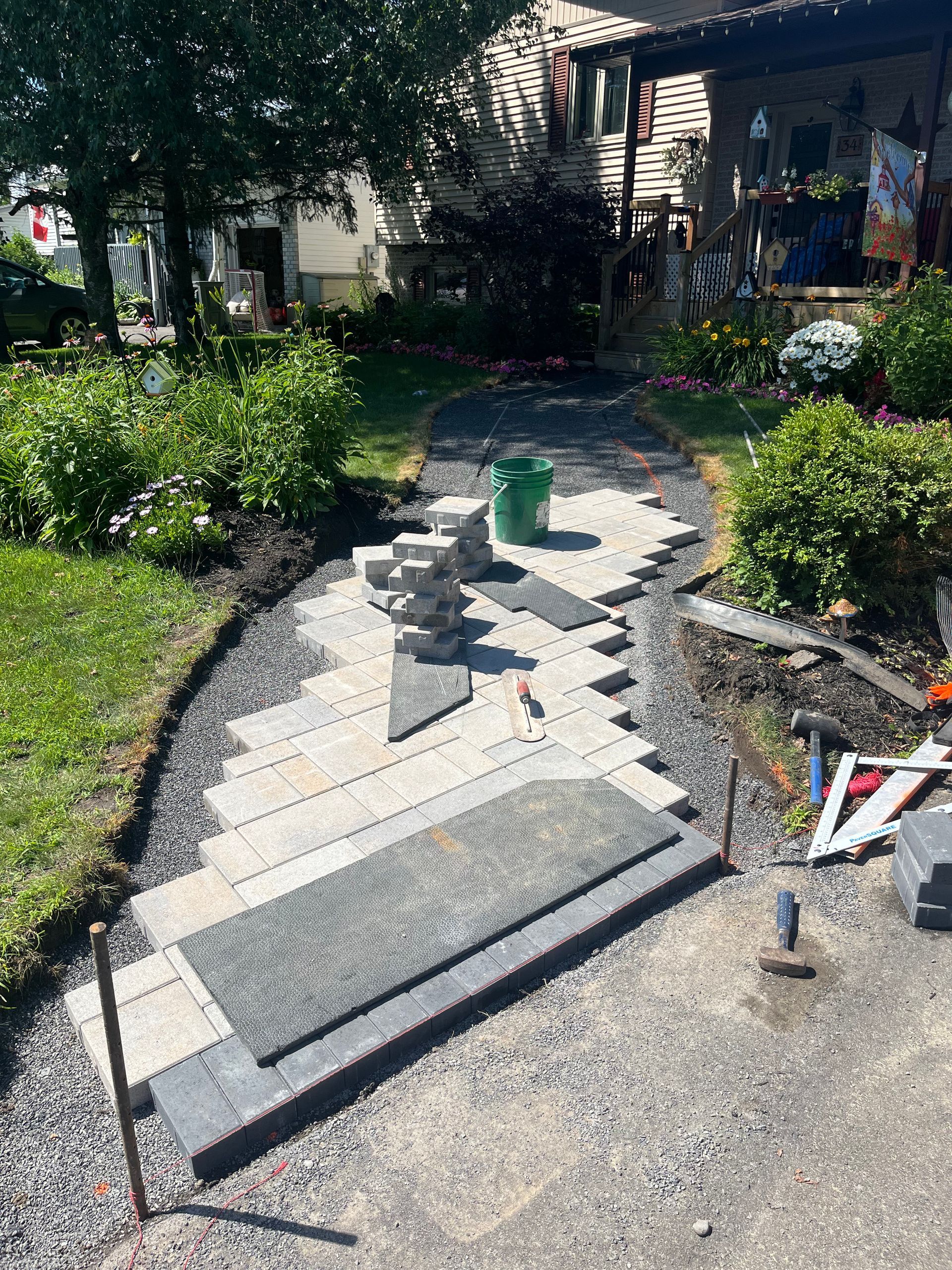 A stone walkway is being built in front of a house.