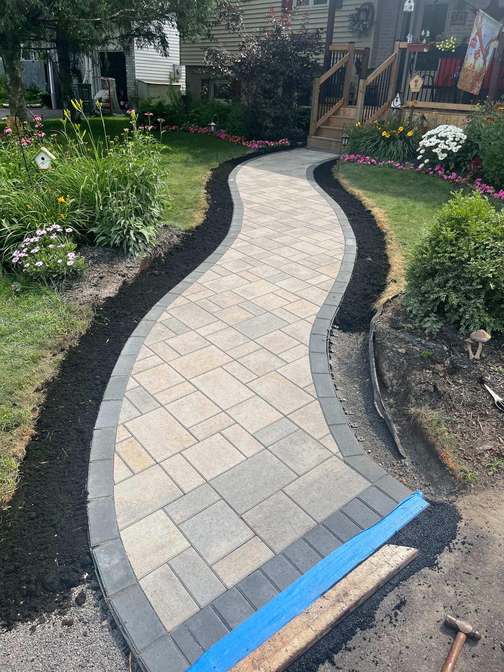 A walkway is being built in the backyard of a house.