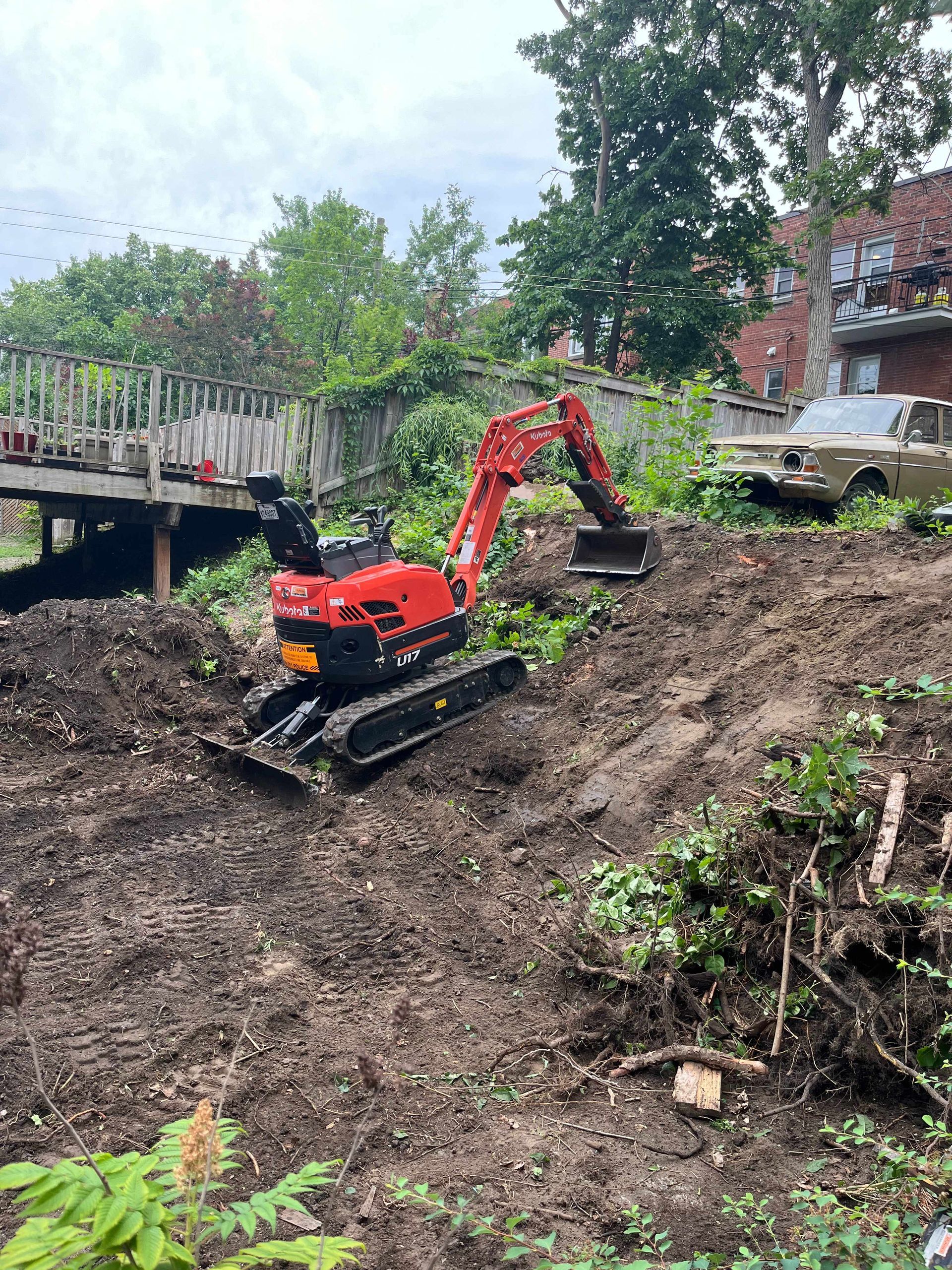 A red excavator is sitting on top of a dirt field.