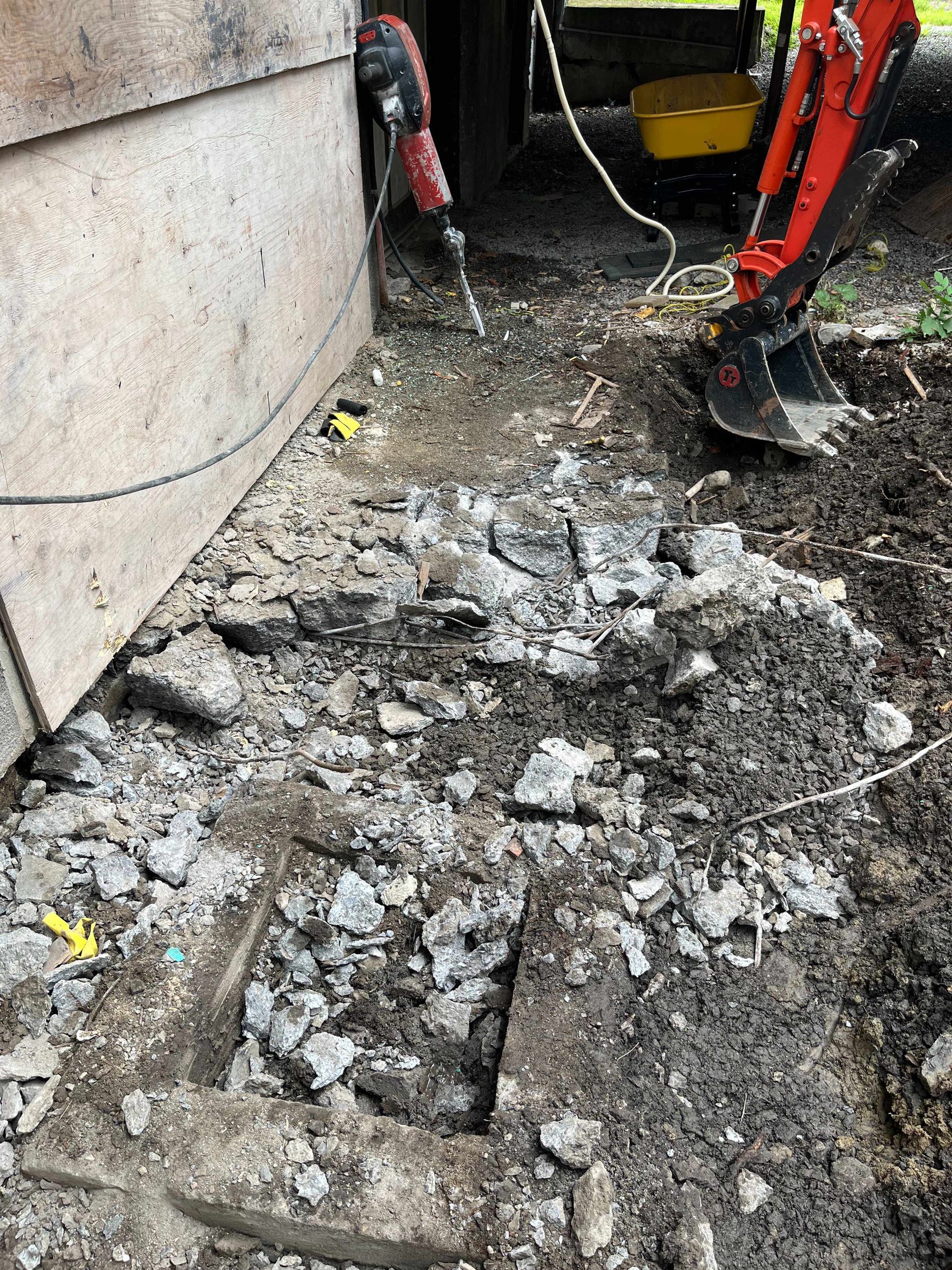 A person is using a hammer to break up concrete.