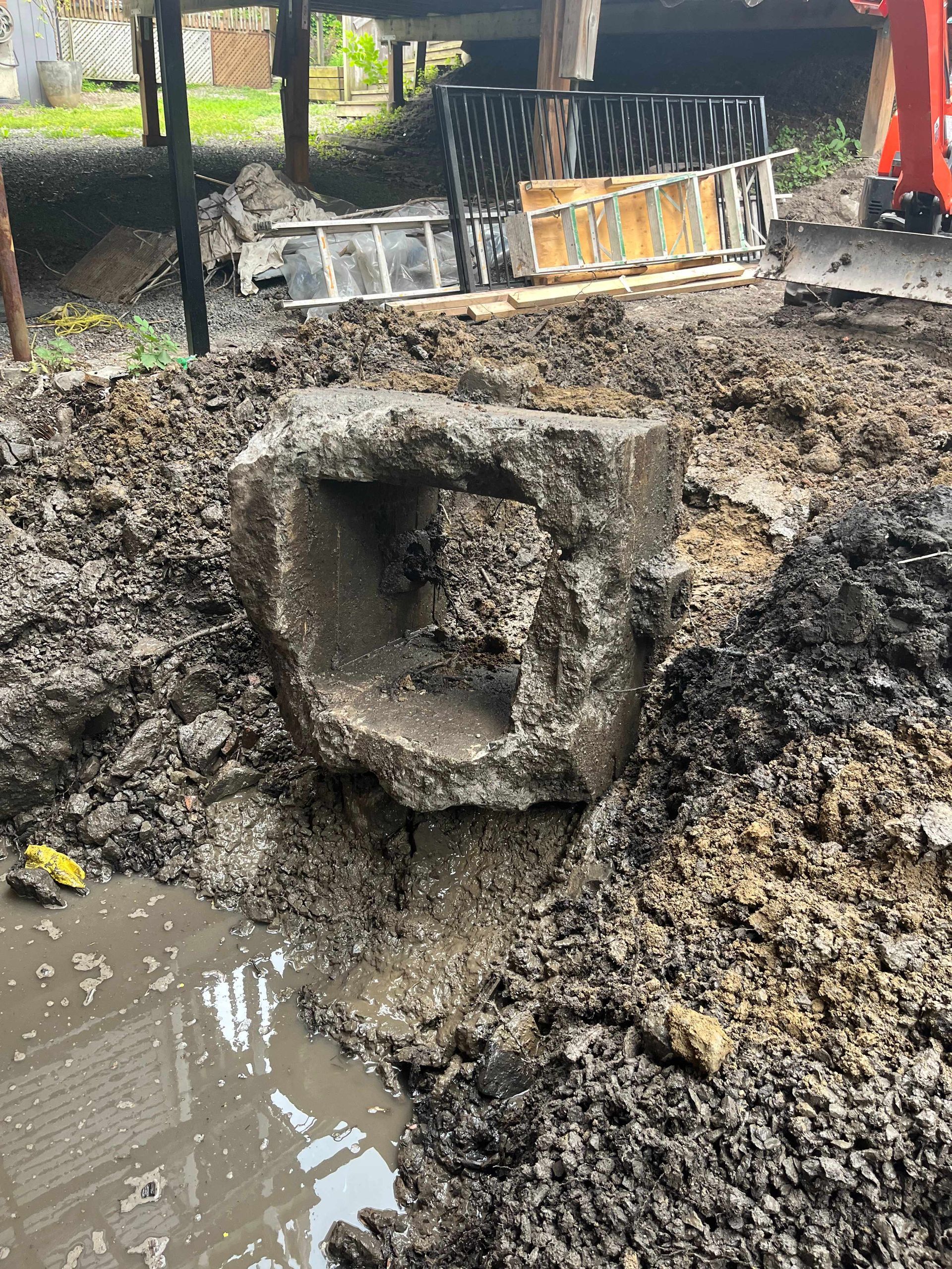 A large rock is sitting in the middle of a pile of dirt.