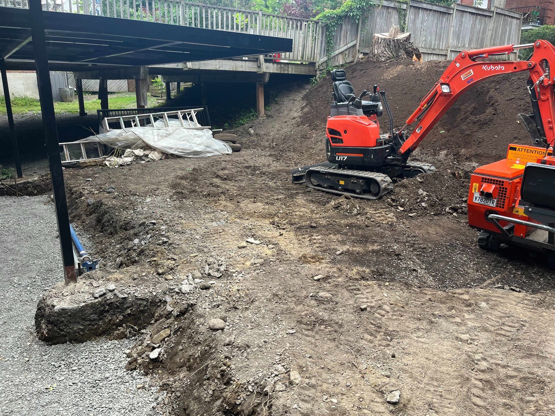 A large red excavator is sitting in the middle of a dirt field.