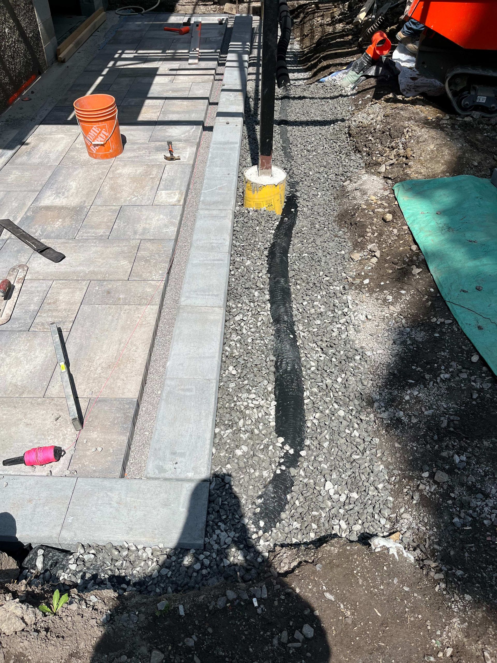 A shadow of a person is cast on a gravel road.