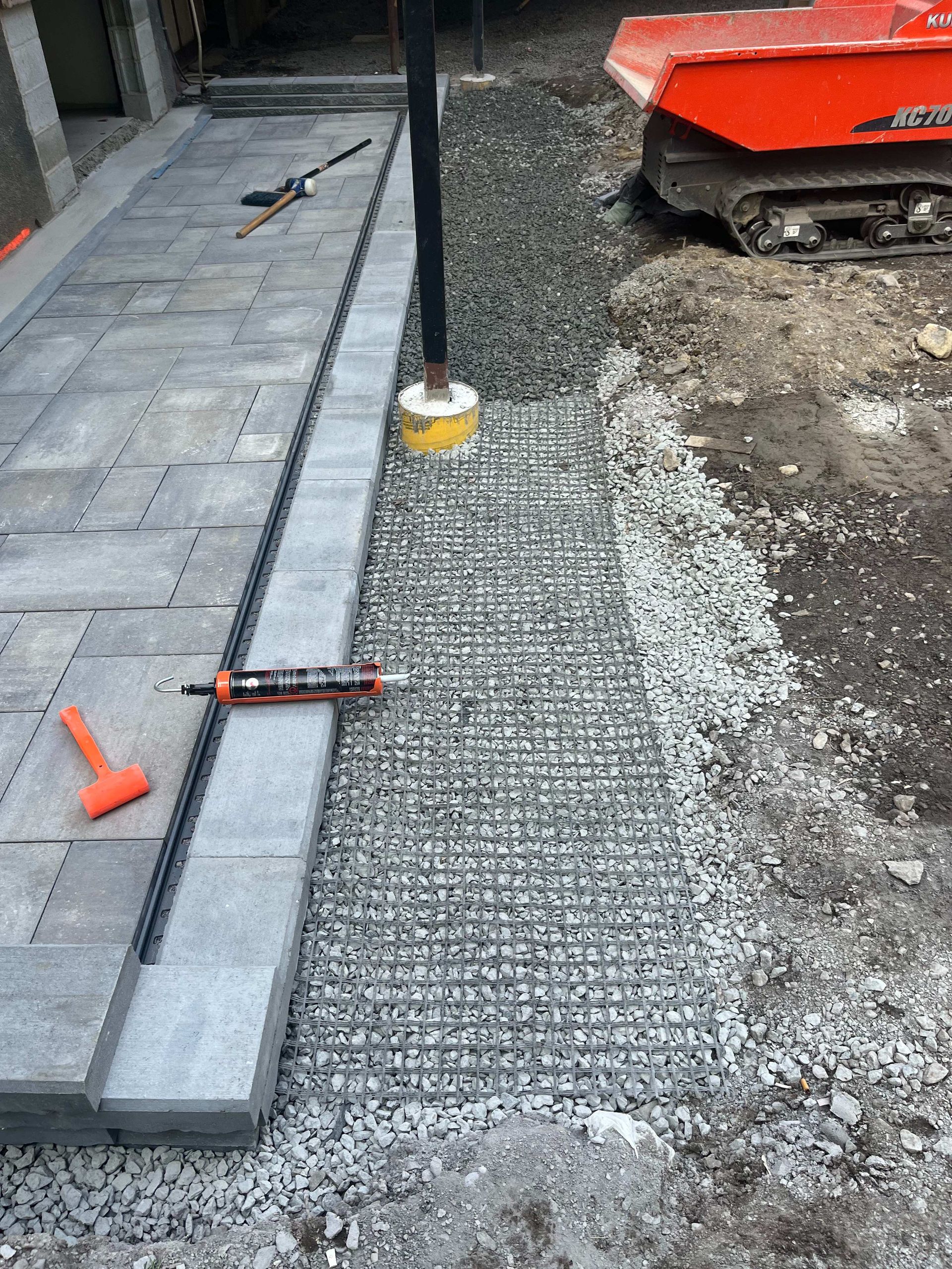 A walkway is being built with bricks and gravel.