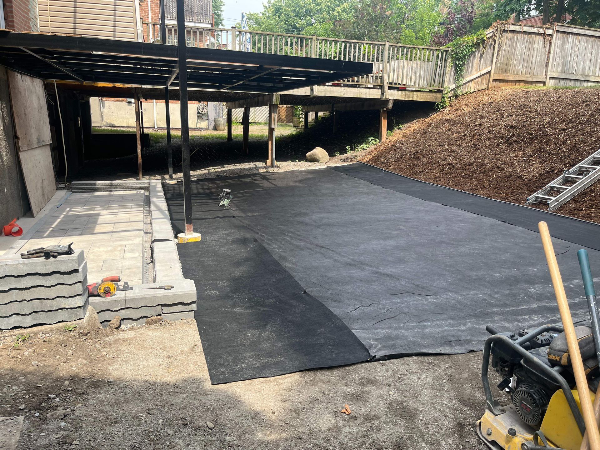 A driveway is being built in the backyard of a house.
