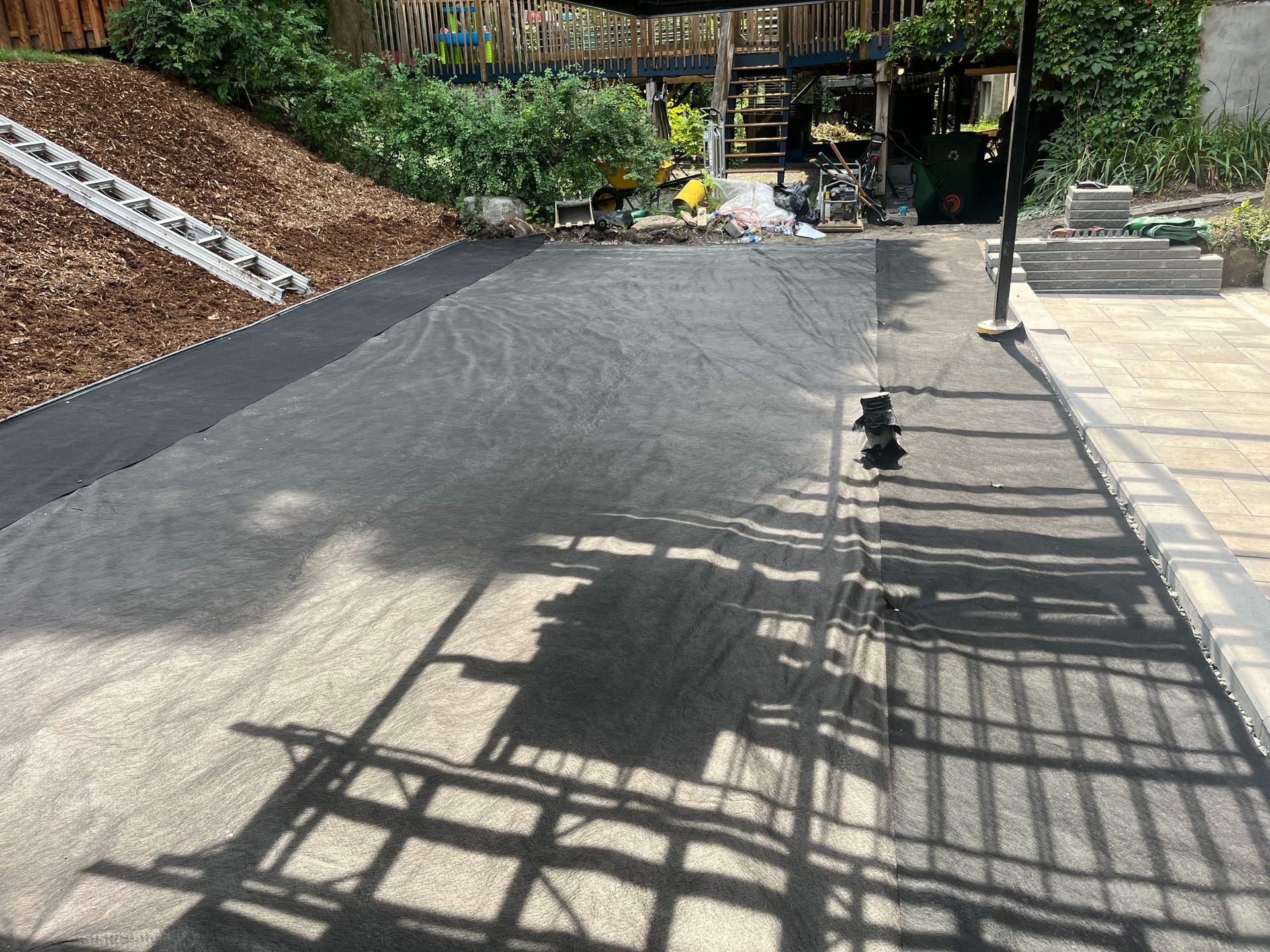 A shadow of a person is cast on the side of a road.