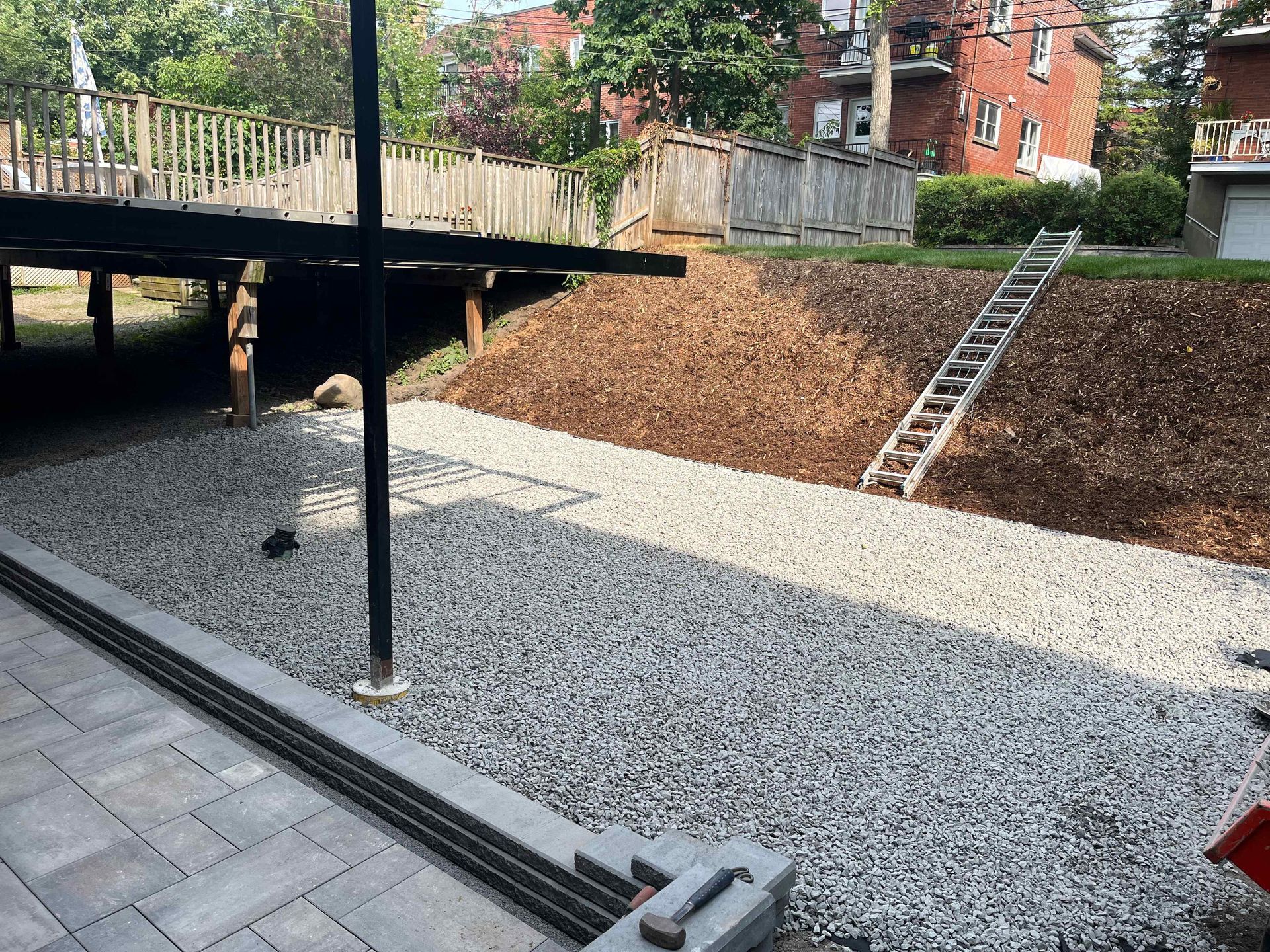 A staircase is going up a hill in a gravel yard.