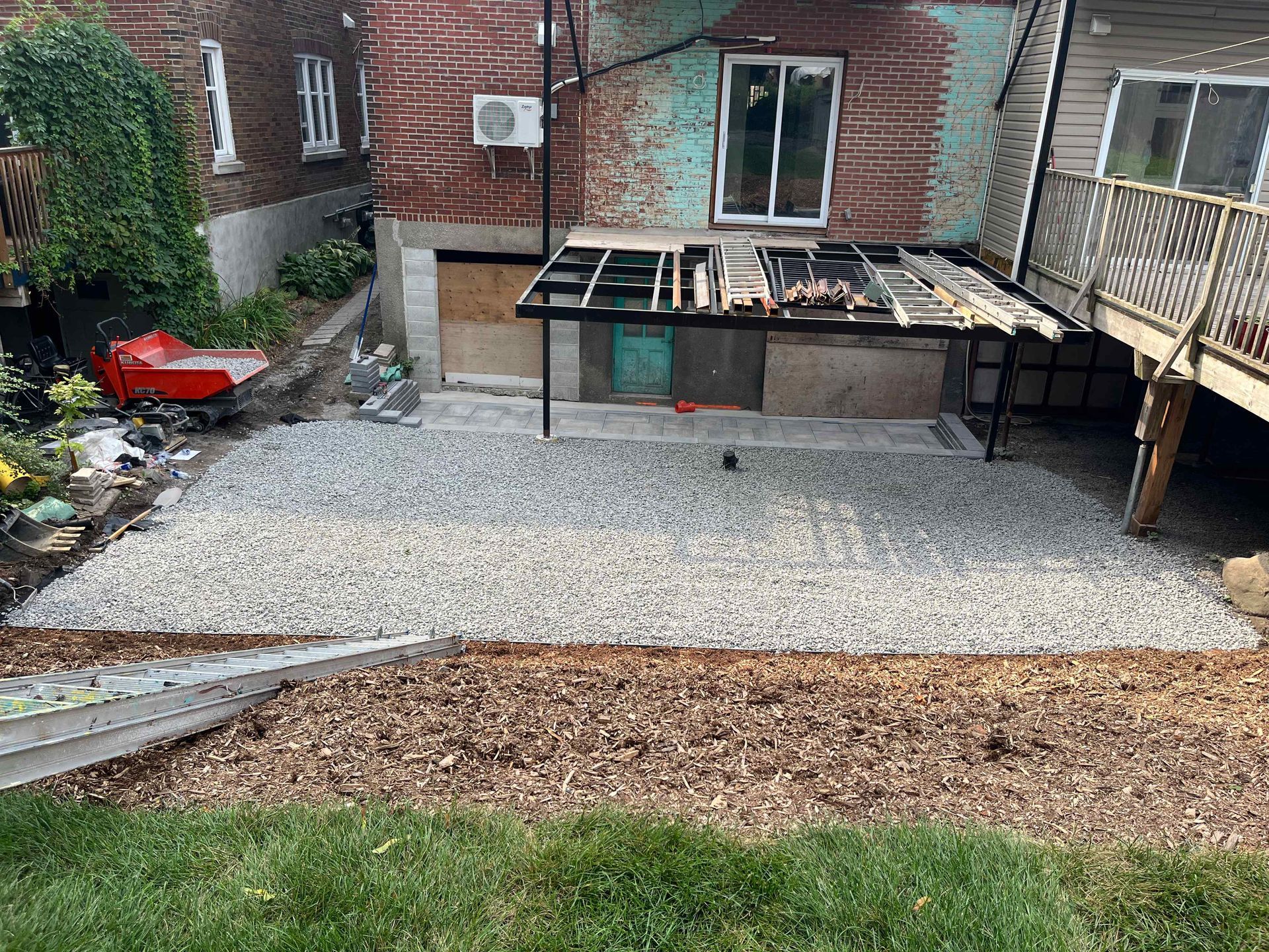 A patio is being built in the backyard of a house.