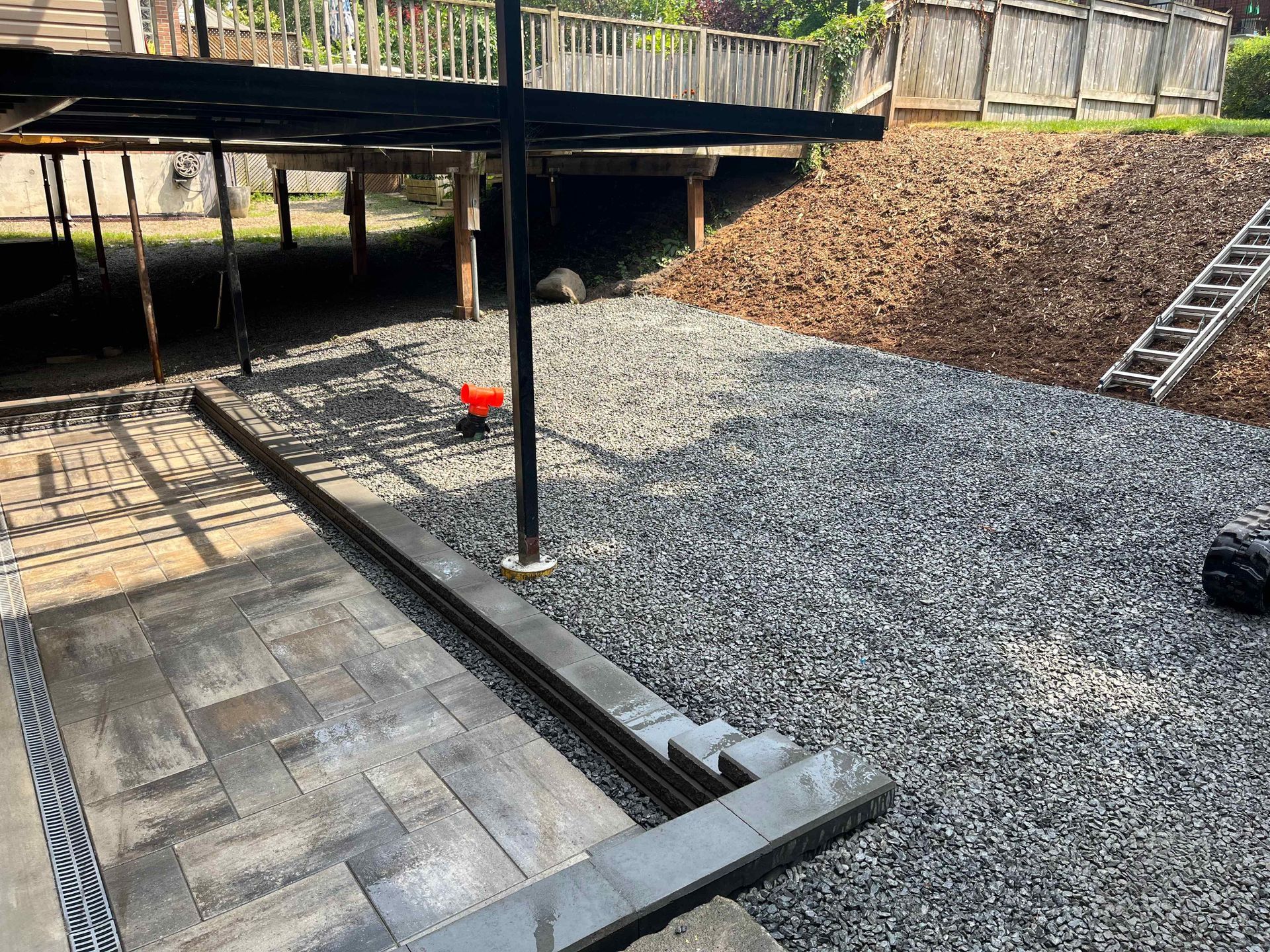 A gravel driveway leading to a deck under construction.