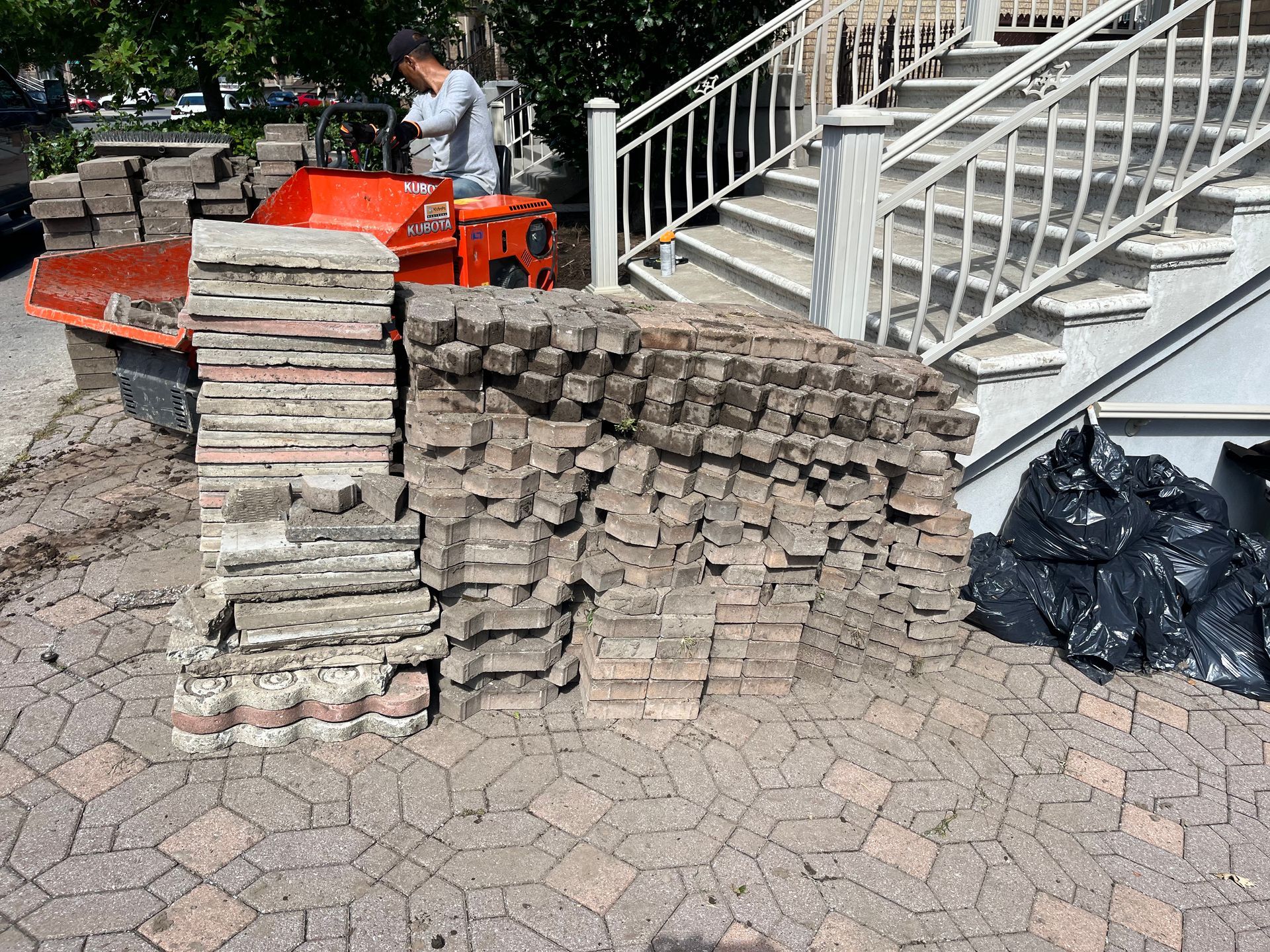 A pile of bricks is sitting in front of a set of stairs.