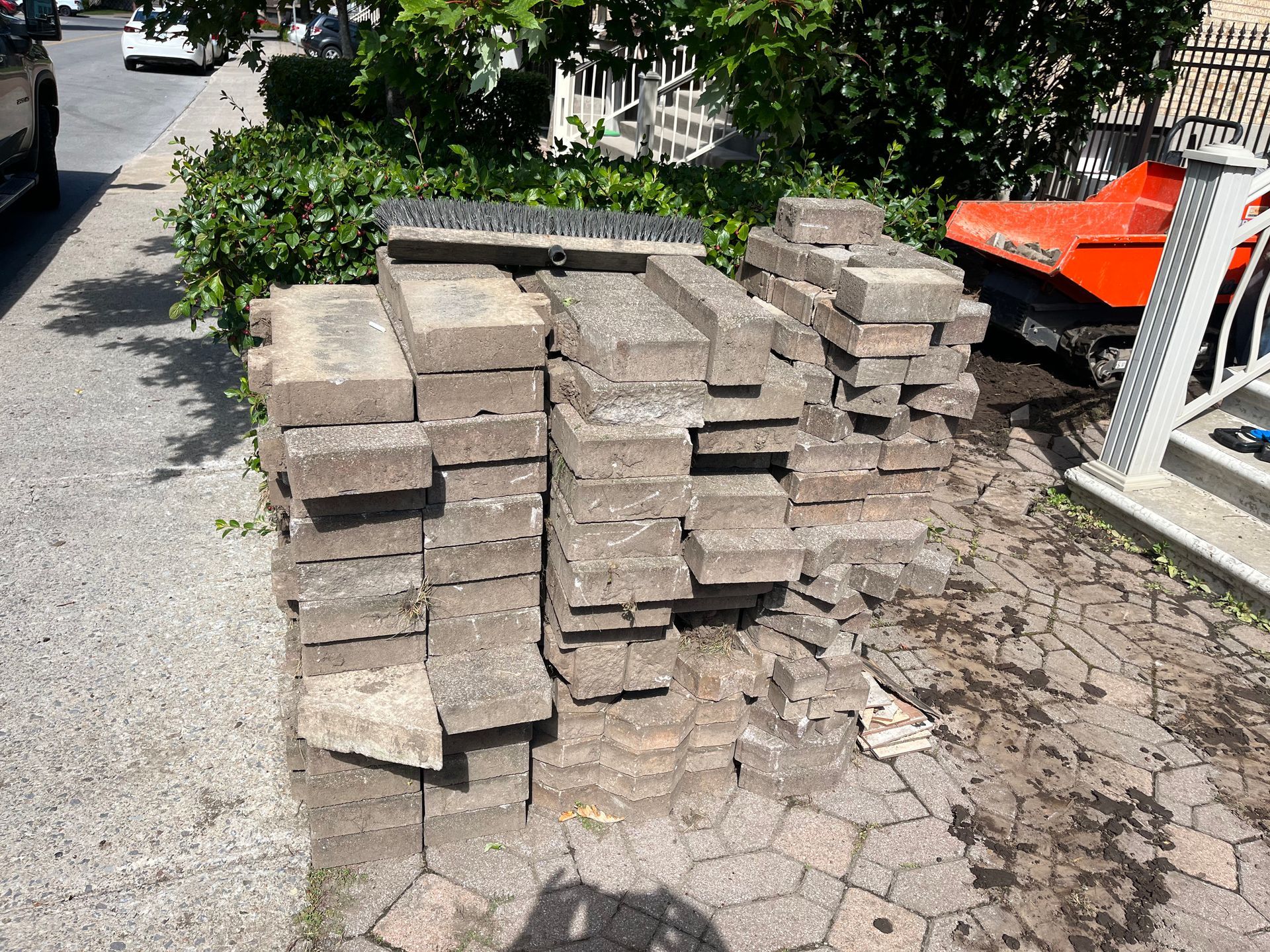 A pile of bricks is sitting on the side of the road.