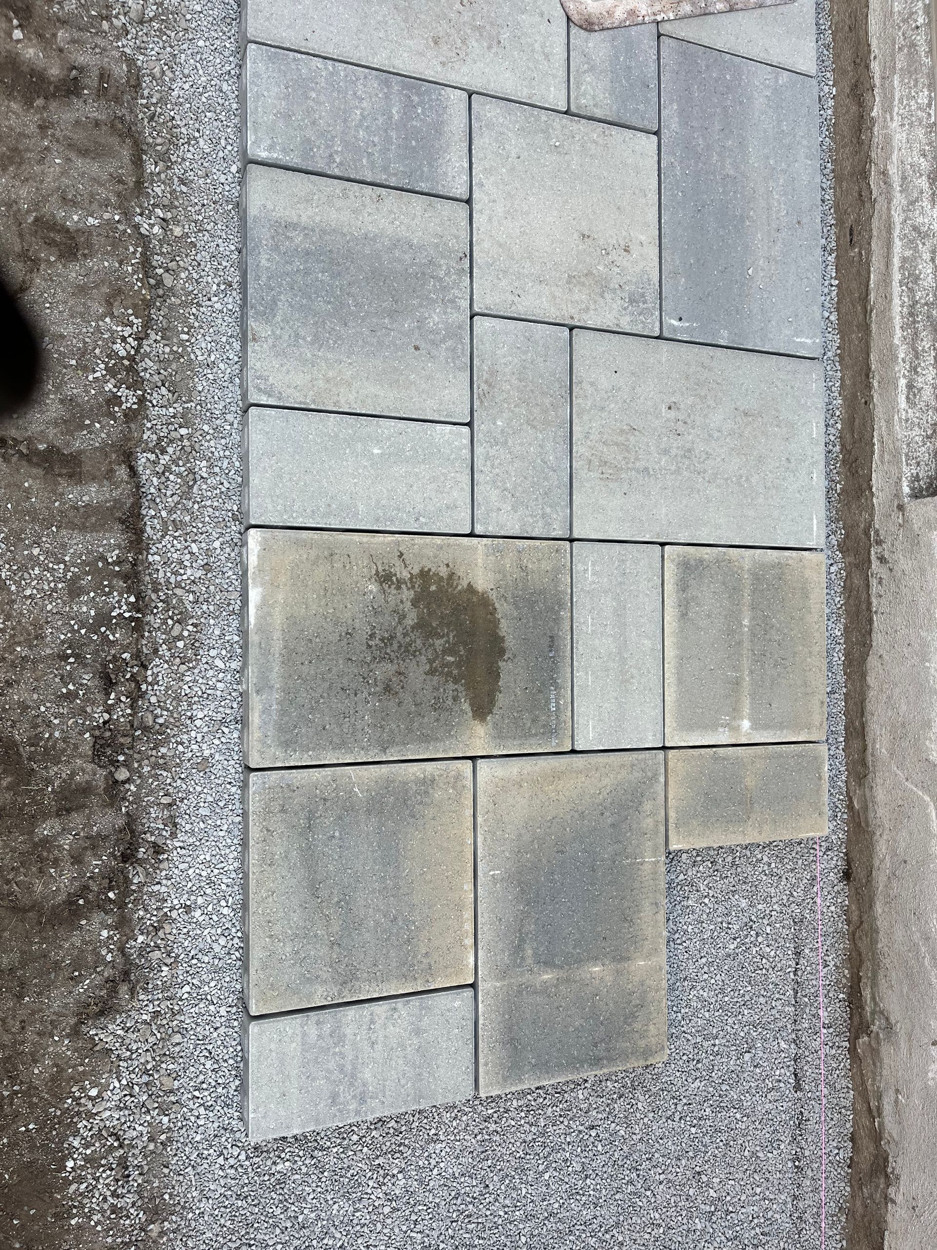 A close up of a sidewalk with bricks and gravel