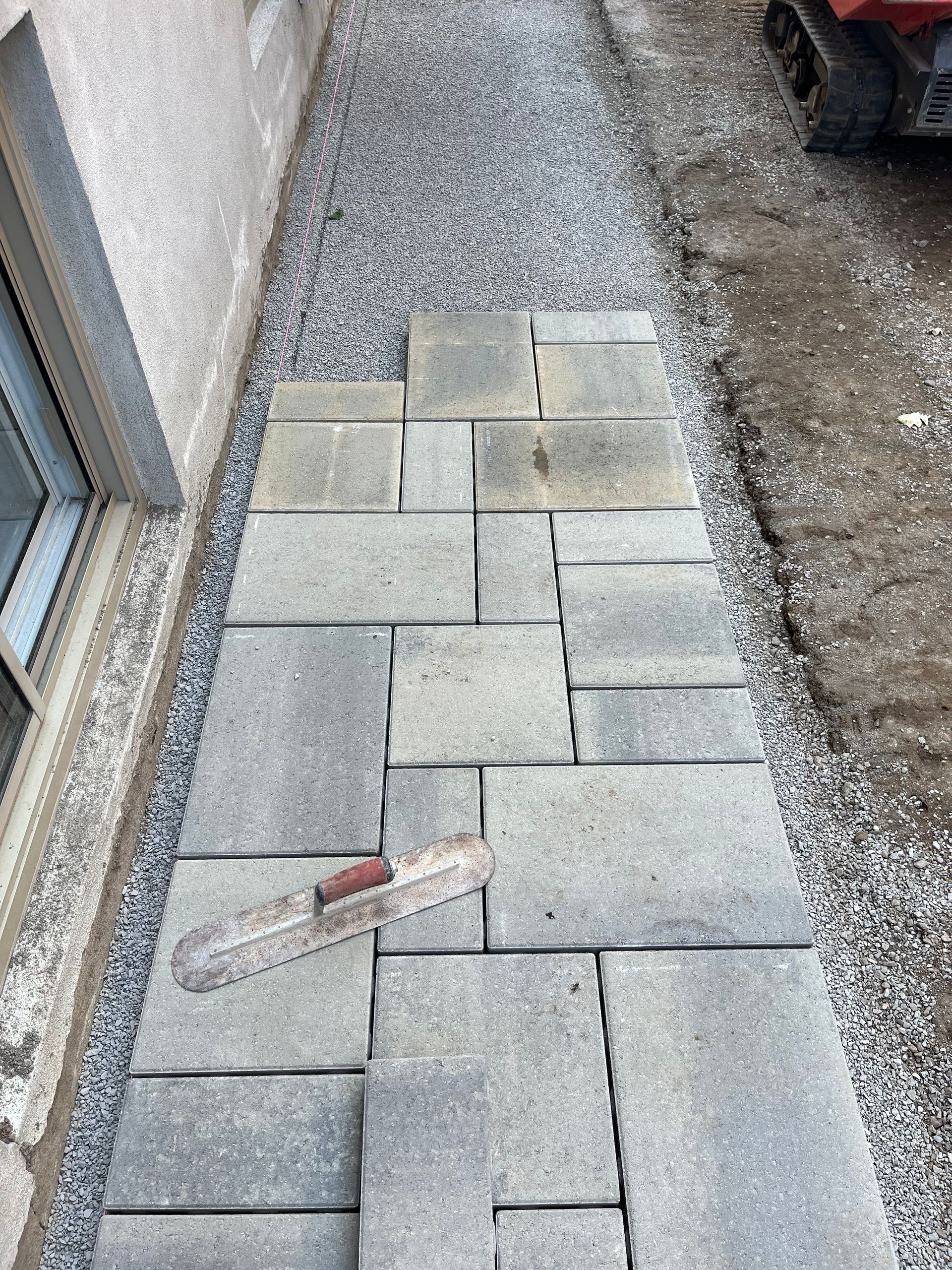A walkway is being built with bricks and gravel.