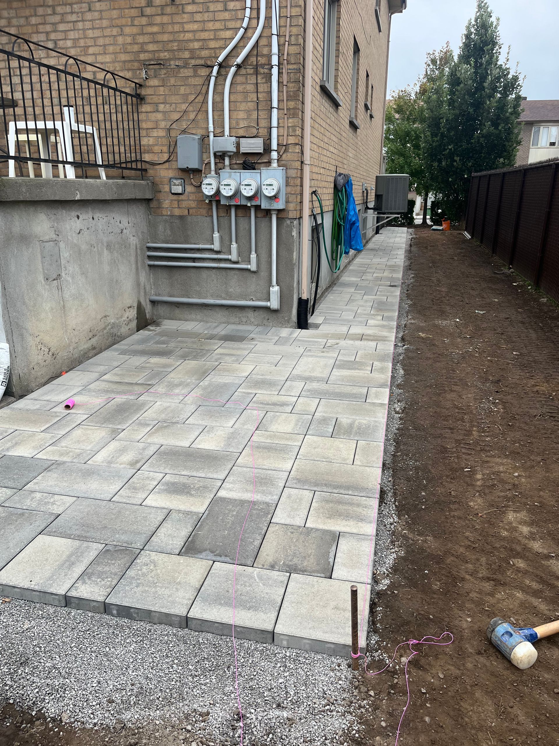 A sidewalk is being built in the backyard of a house.